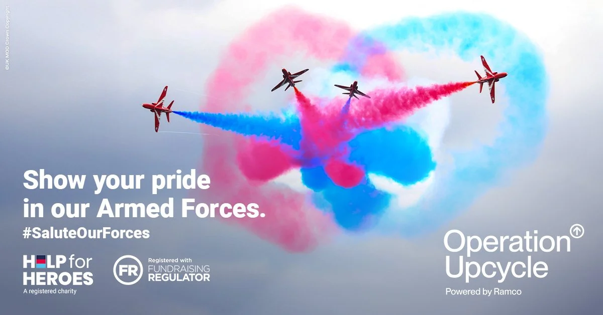 Four fighter jets performing an aerial display, releasing red, blue, and pink smoke trails in the shape of a heart.