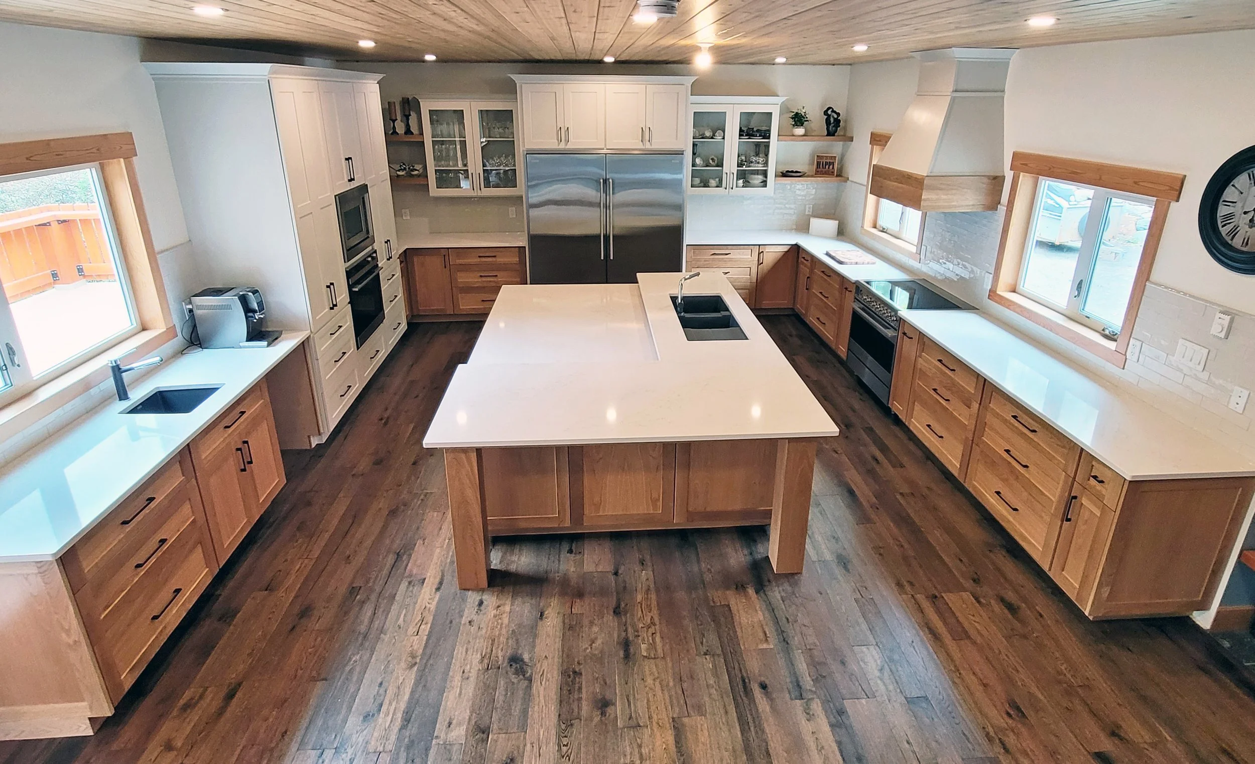 Modern kitchen with wood cabinets, stainless steel appliances, and a central island with a wood base and white countertop