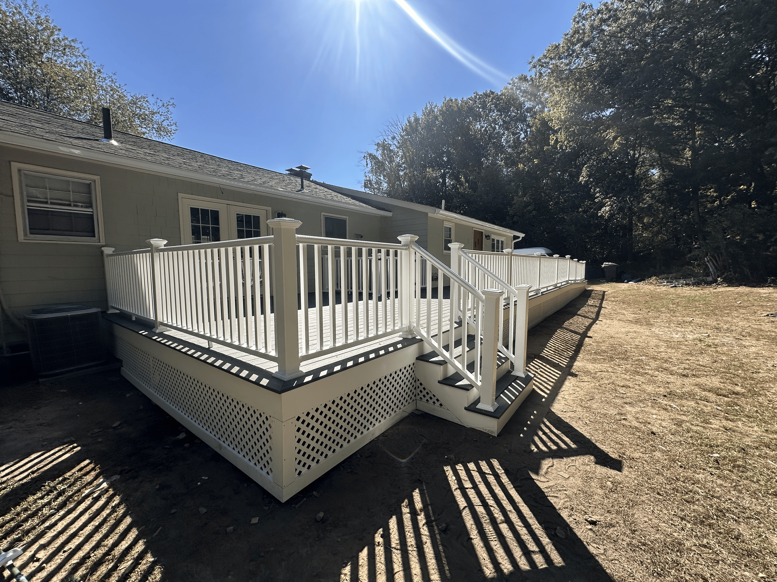 Side-by-side comparison of a house deck construction process. The top image shows the early framing stage with exposed wooden beams, and the bottom image shows the completed white deck with railing.