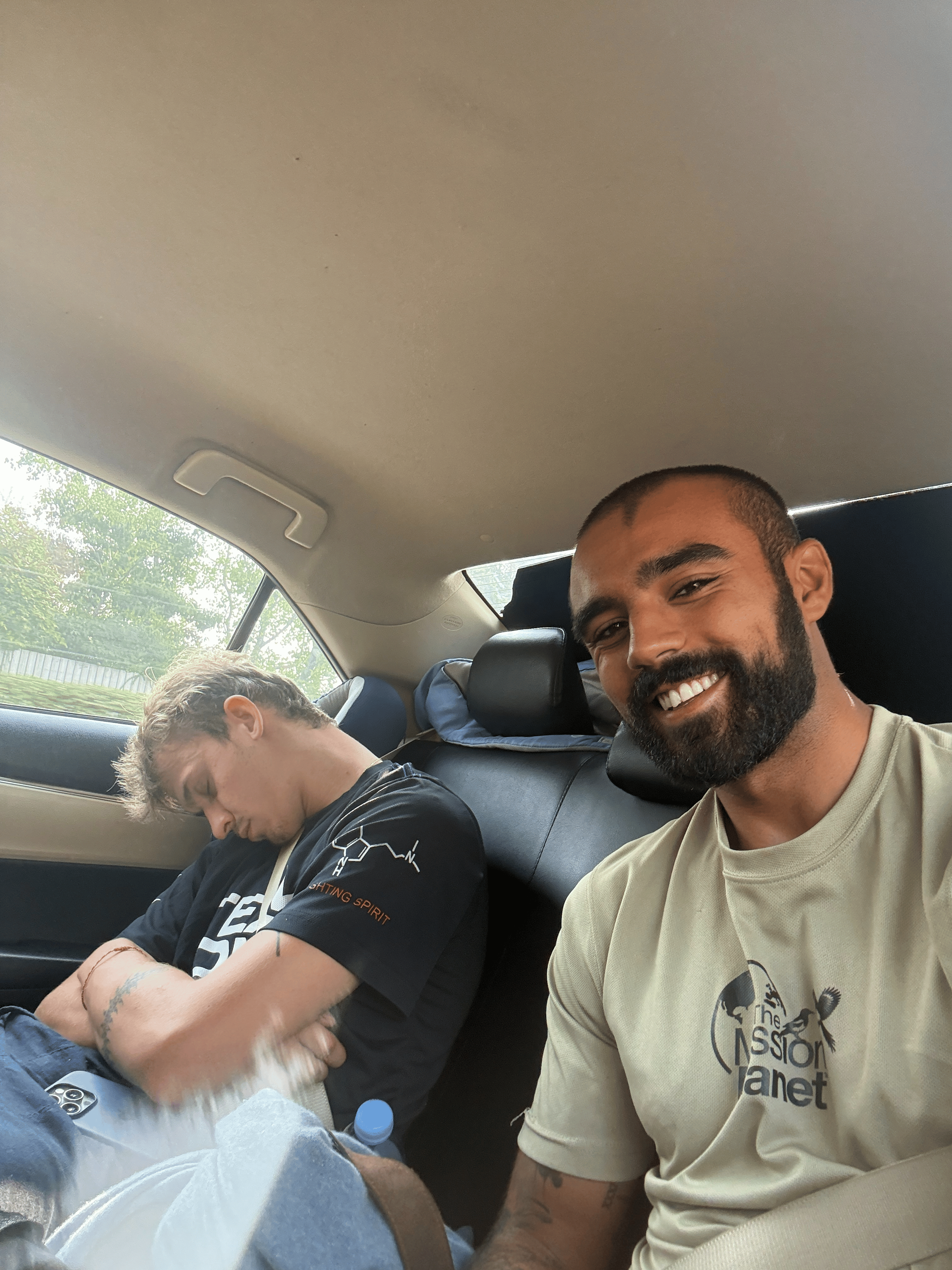 Rohan and Tom resting while travelling by car during a Mission Planet journey between mission locations