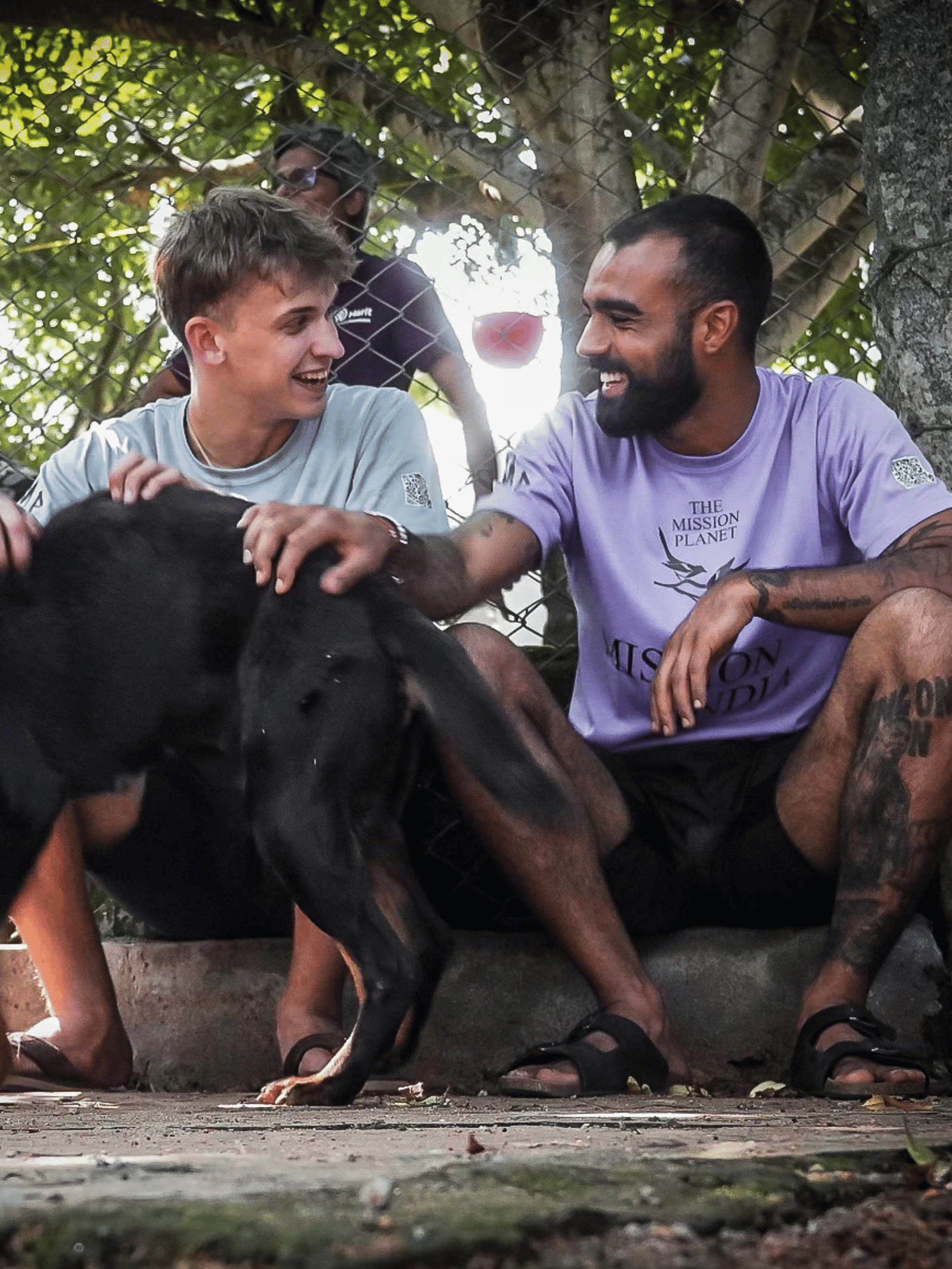 Rohan and Tom spending time with a rescued street dog outdoors during a Mission Planet animal welfare mission