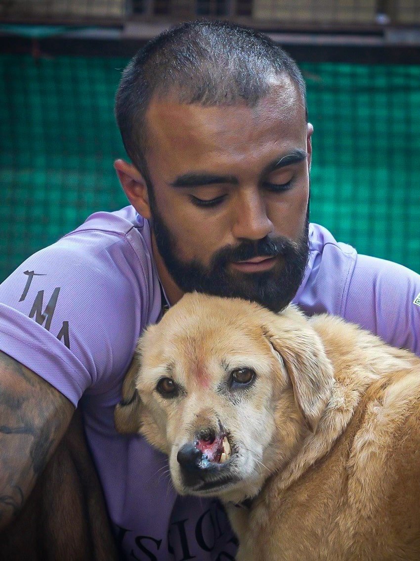 Rohan from The Mission Planet CIC comforting an injured rescue dog during an animal welfare initiative in India.