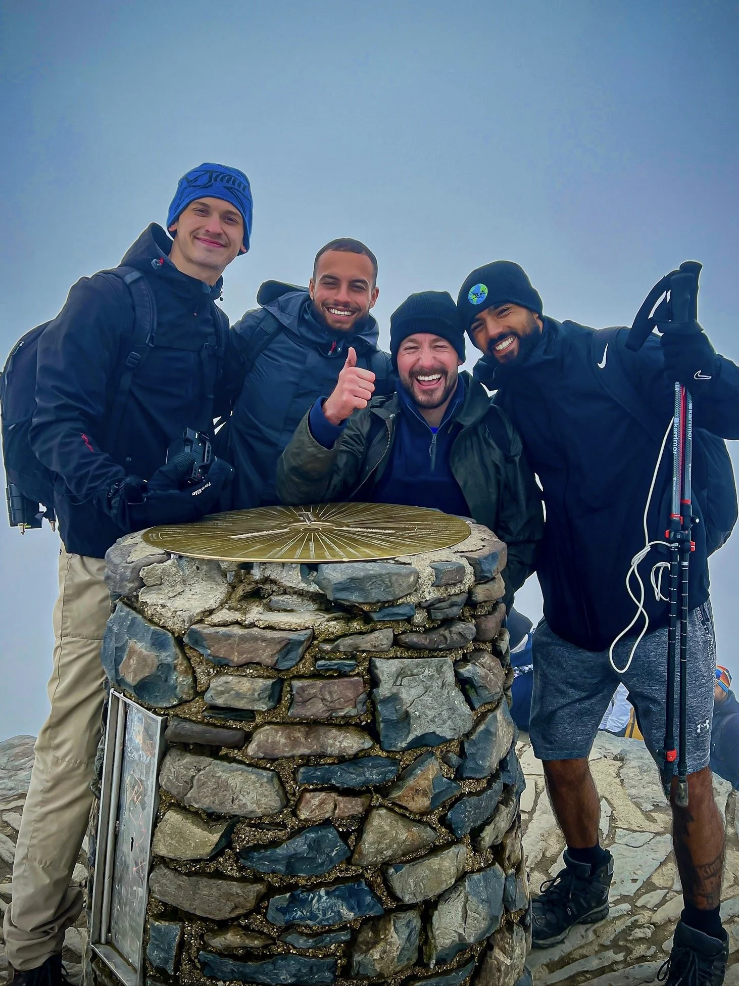 Joe Bird, who has cerebral palsy, reaching the summit of Snowdon alongside supporters during a fundraising climb documented by The Mission Planet CIC.