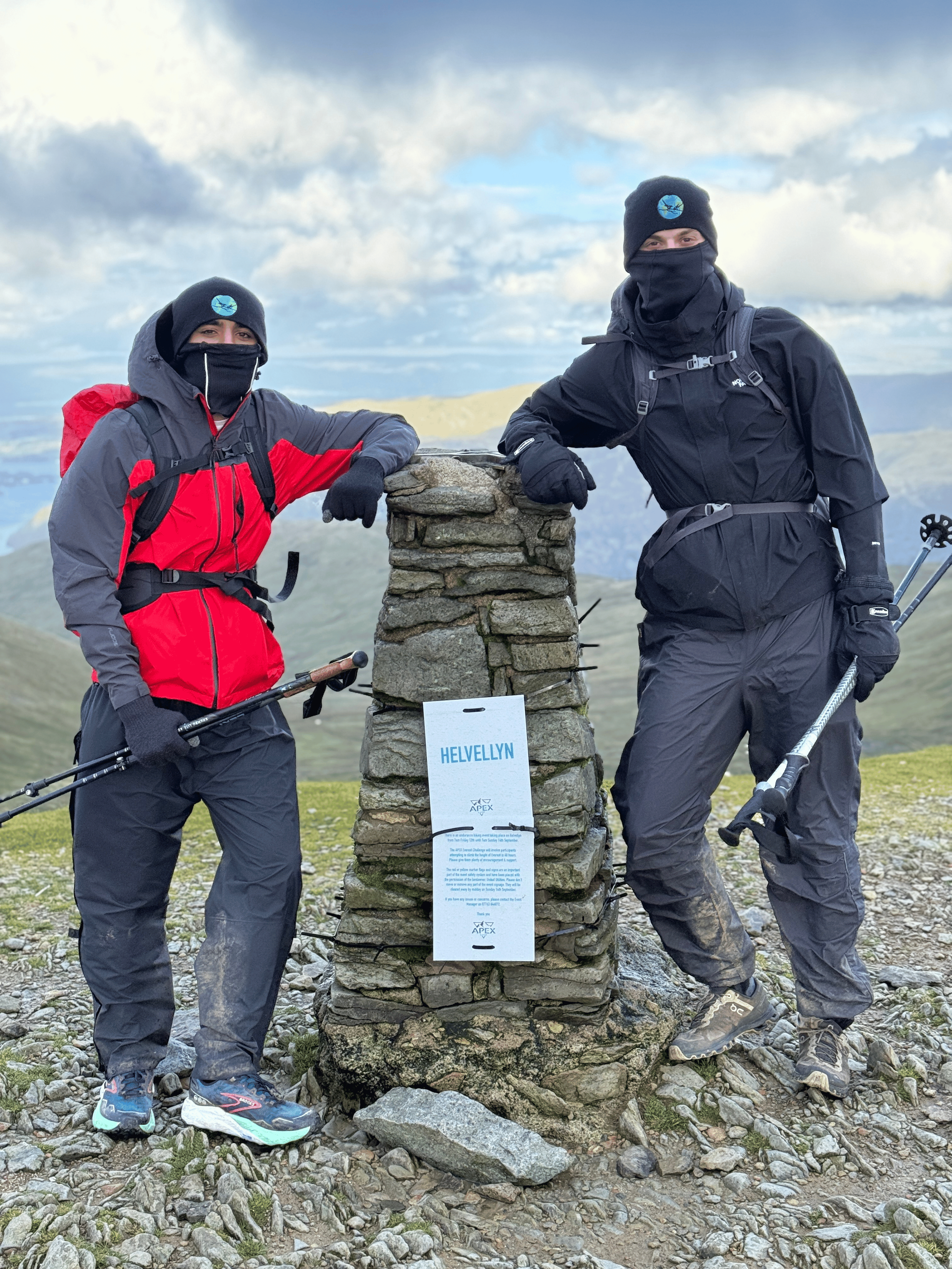 Rohan and Tom reaching a mountain summit marker during a Mission Planet endurance journey