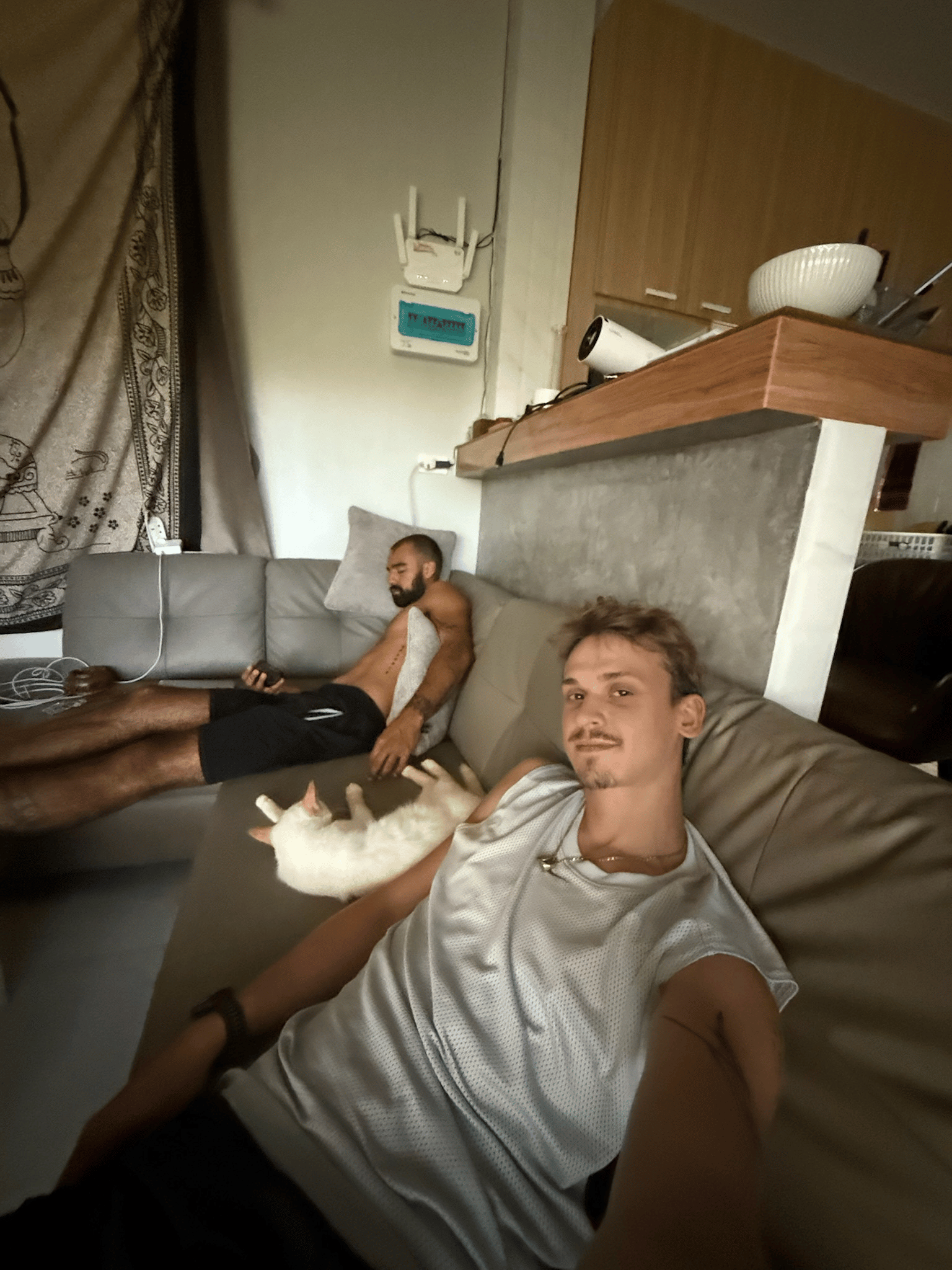 Rohan and Tom relaxing indoors with Sky the jungle cat rescued by the founders of The Mission Planet
