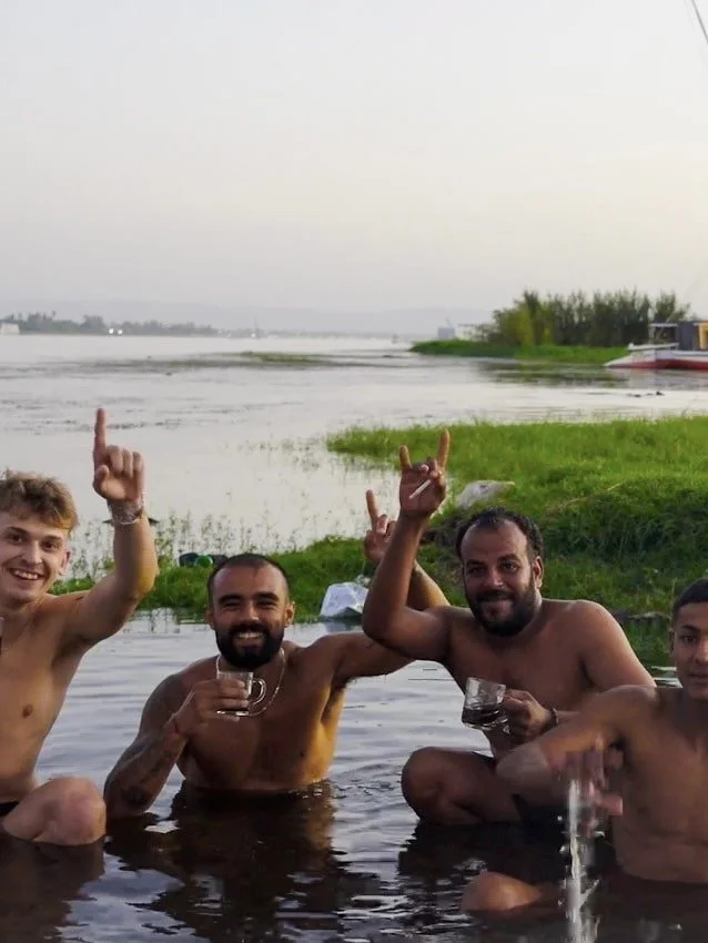 Rohan and Tom from The Mission Planet CIC with local community members during a global trip supporting animal welfare initiatives.