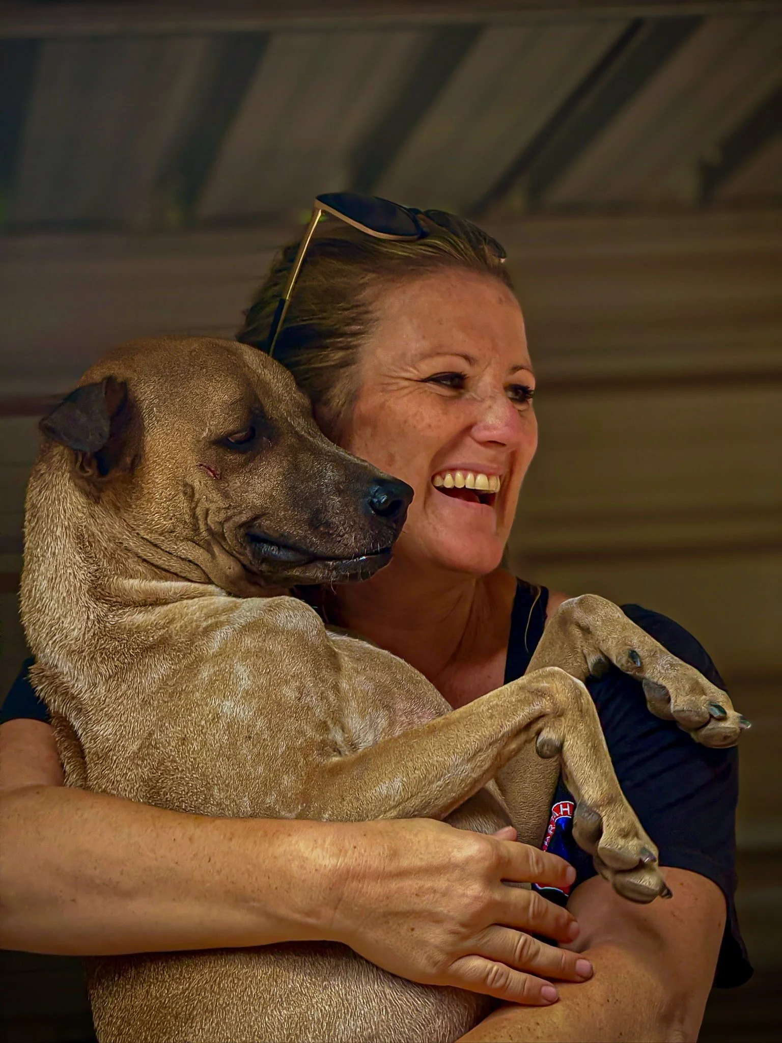 Founder of a dog sanctuary in Egypt holding a rescued dog during an animal welfare initiative supported by The Mission Planet CIC.
