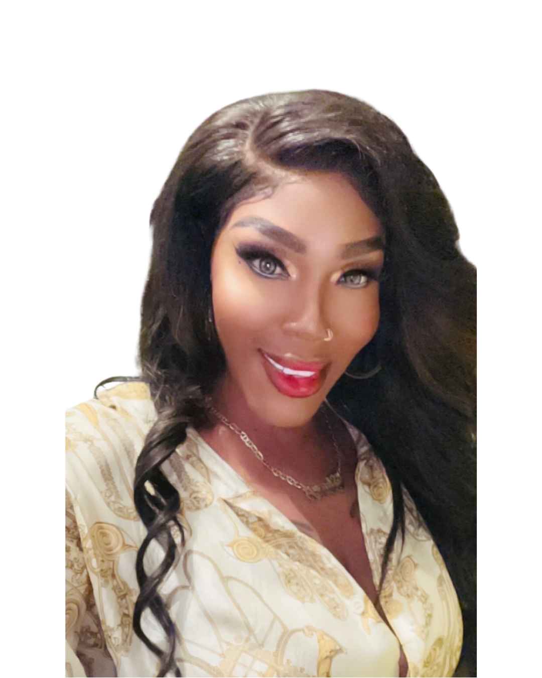 A woman with short red hair, wearing a black spaghetti strap dress, gold jewelry, and with visible tattoos on her chest, sitting against a white background.