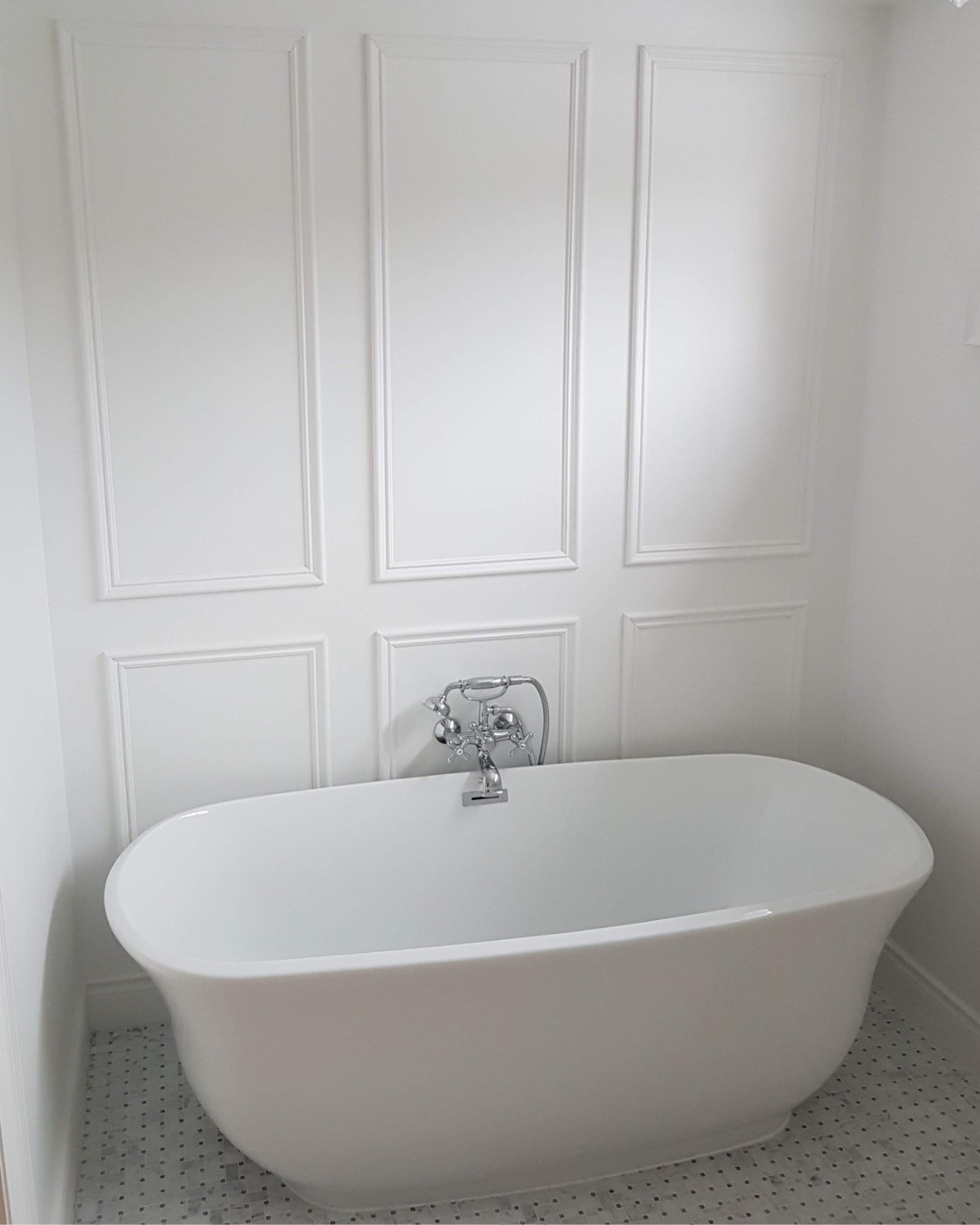 Bright bathroom renovation featuring a freestanding tub and custom finishes.