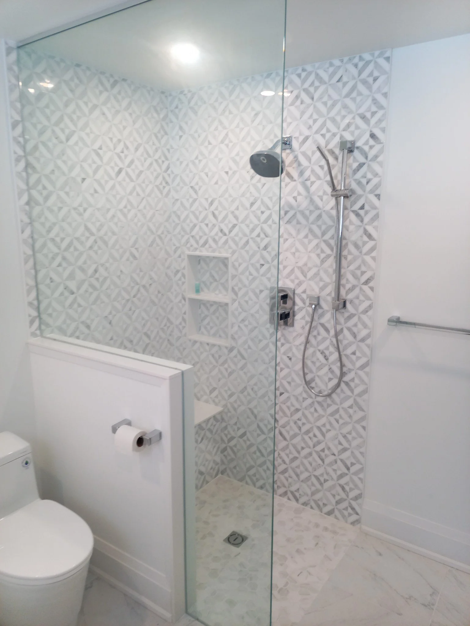 Walk-in shower renovation with custom tile and glass enclosure.