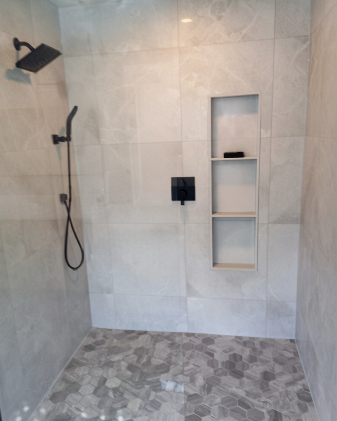 Custom tiled shower with built-in niche .
