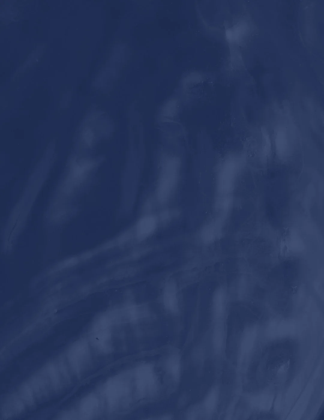 A close-up of a dark blue surface with some lighter streaks and smudges.
