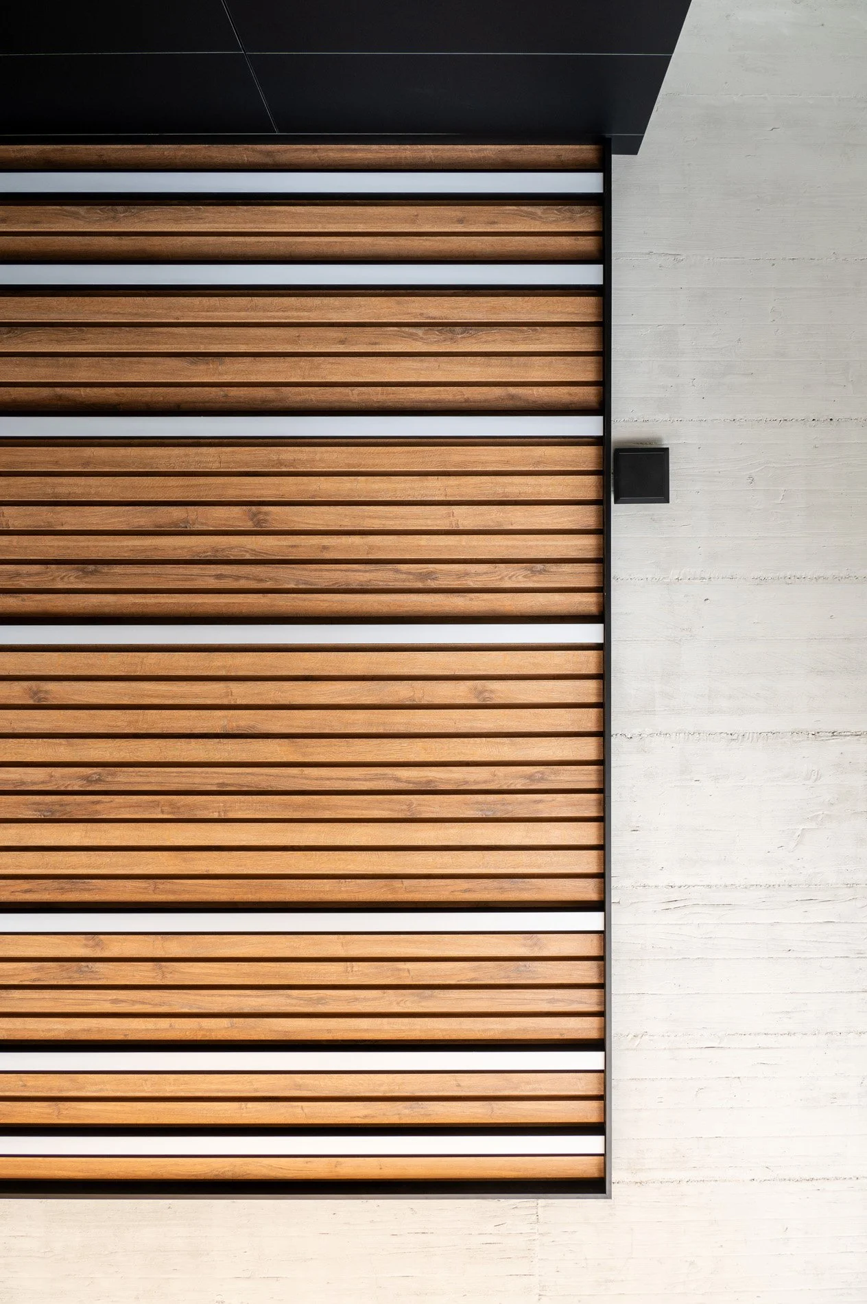 Modern building facade with horizontal wooden slats and concrete wall.