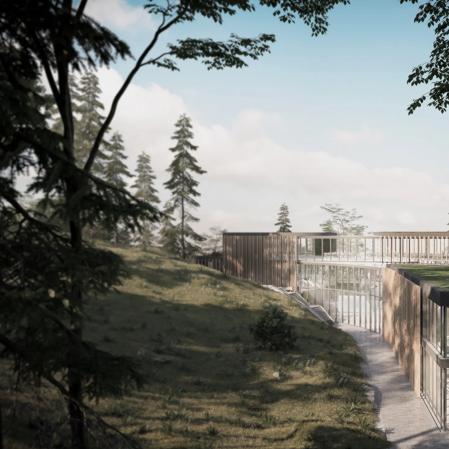 Modern building with glass and wood exterior, surrounded by trees and grass, on a hillside under a partly cloudy sky.