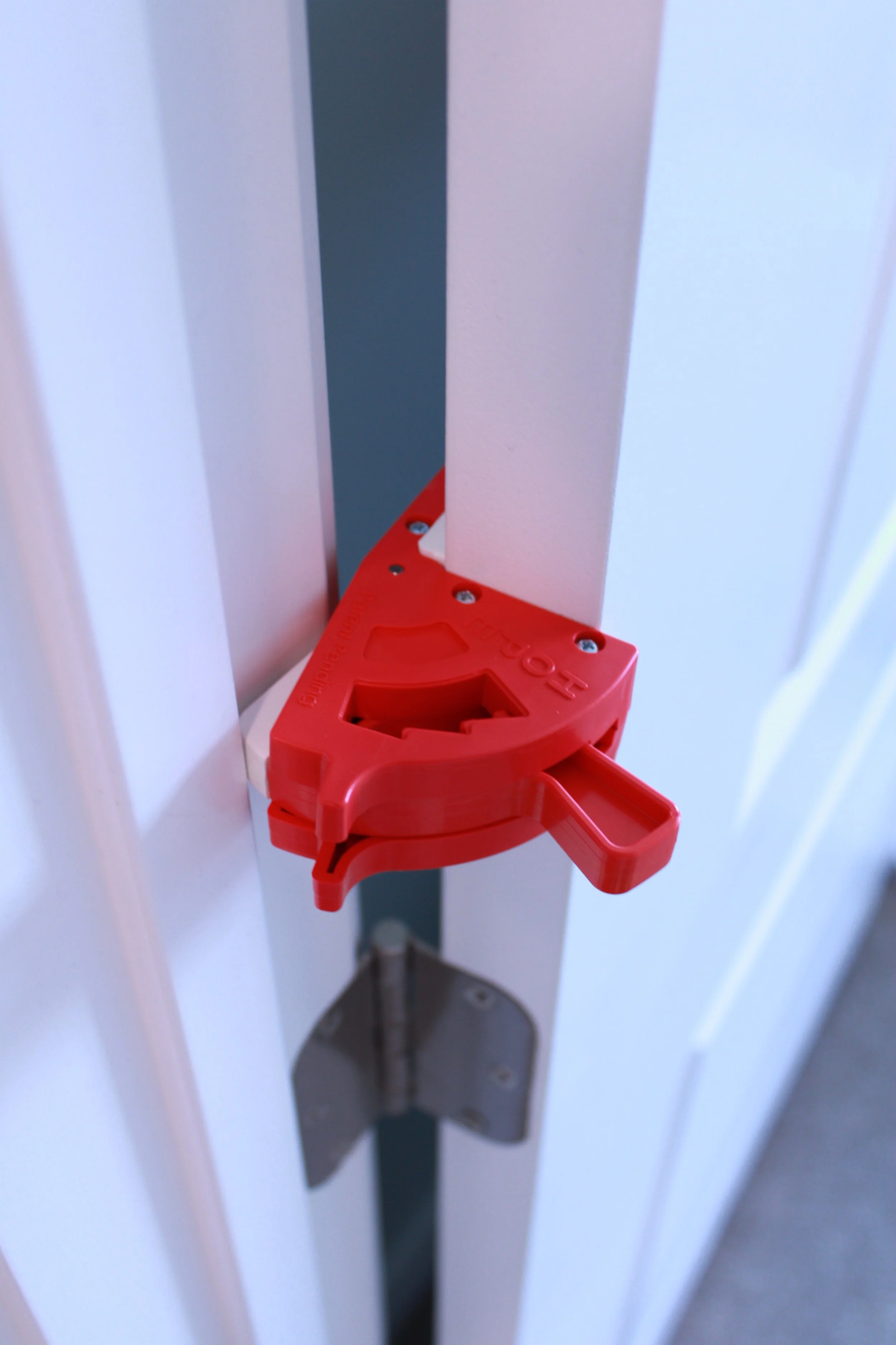 Close-up of a red safety lock on a door latch mechanism.
