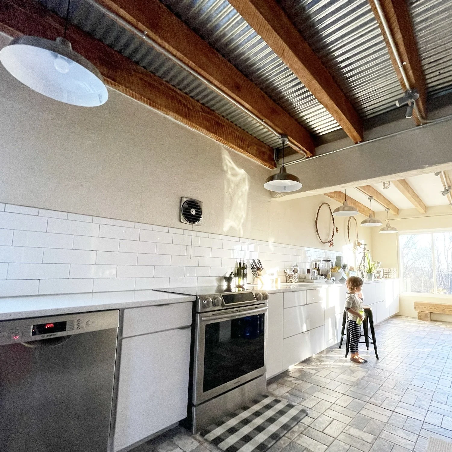 The metal ceiling featuring the home's original wood beams, refinished
