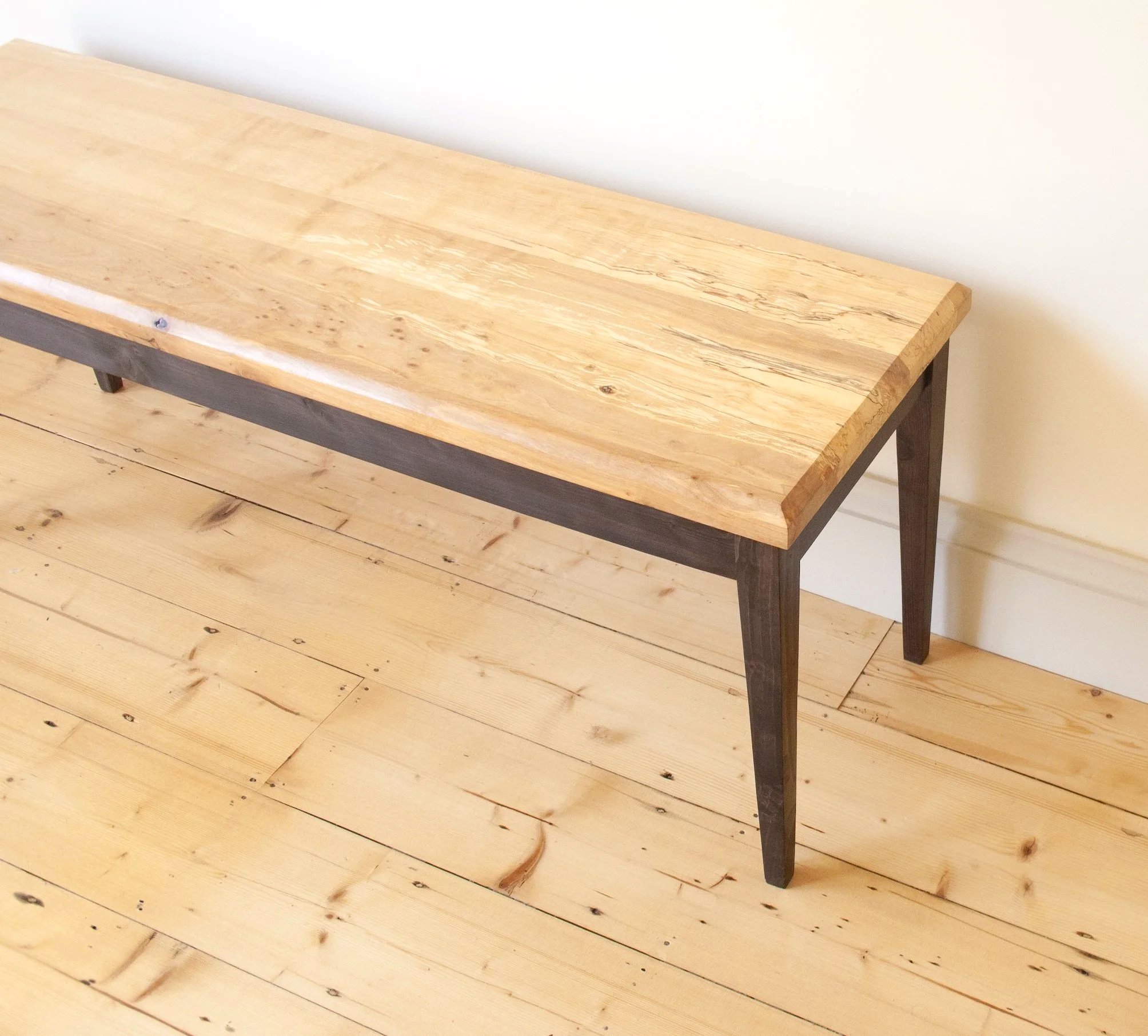 The Calder bench a simple black stained elegant leg frame with a spalted timber top