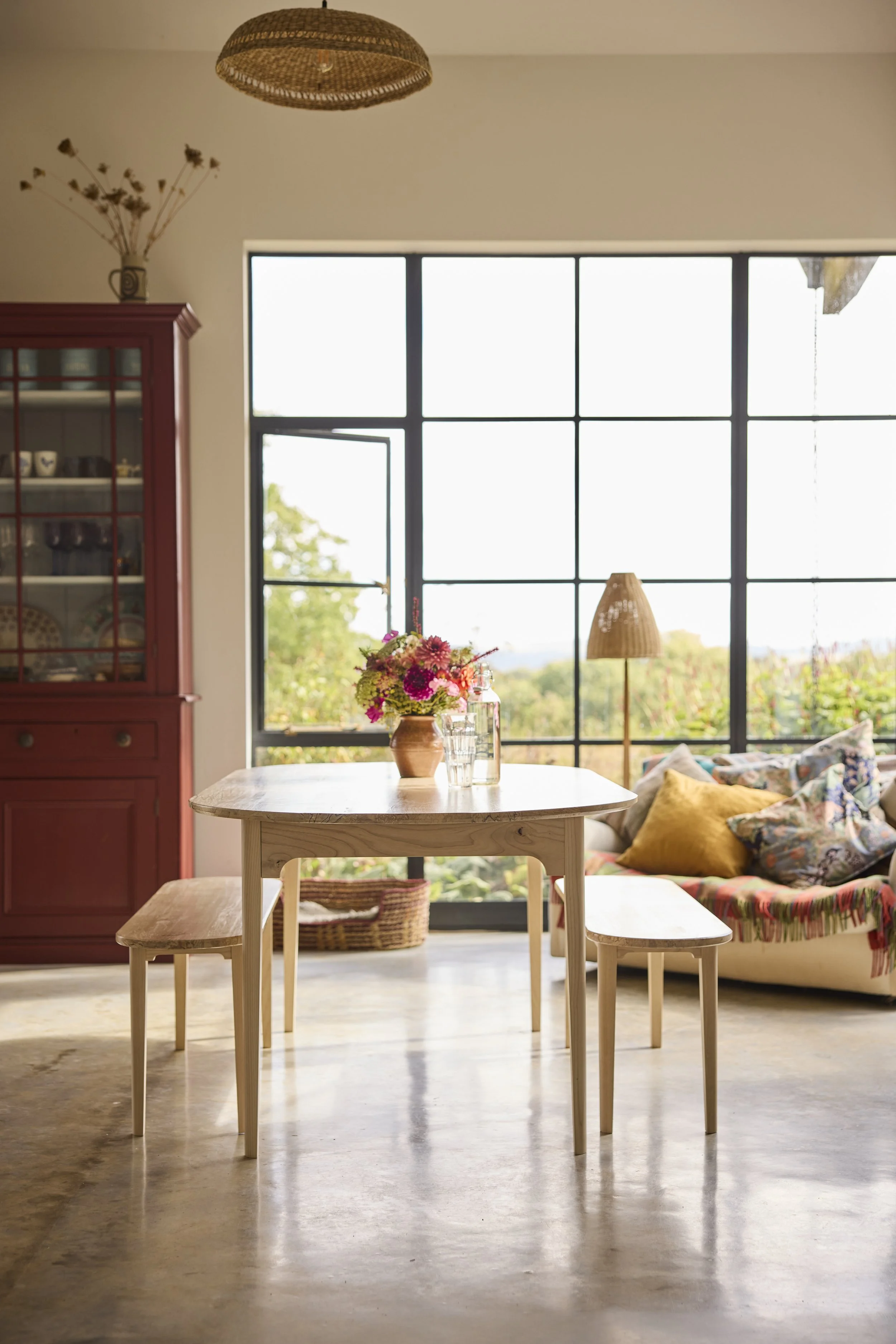 Bright dining area with solid wood table and benches made in a workshop near Bath