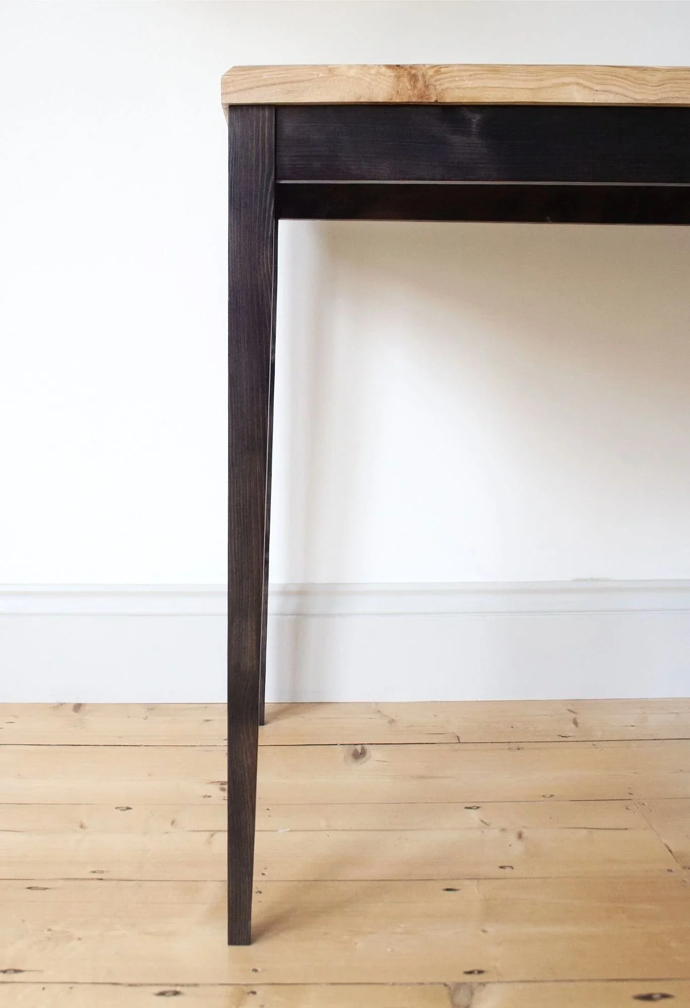 The Calder Table, a detail of the elegant black stained legs