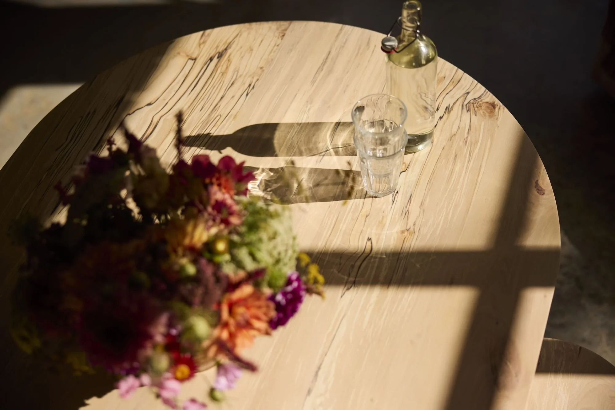 Sunlit table top of The Orwin handmade with beautiful spalted silver birch in our Bristol workshop