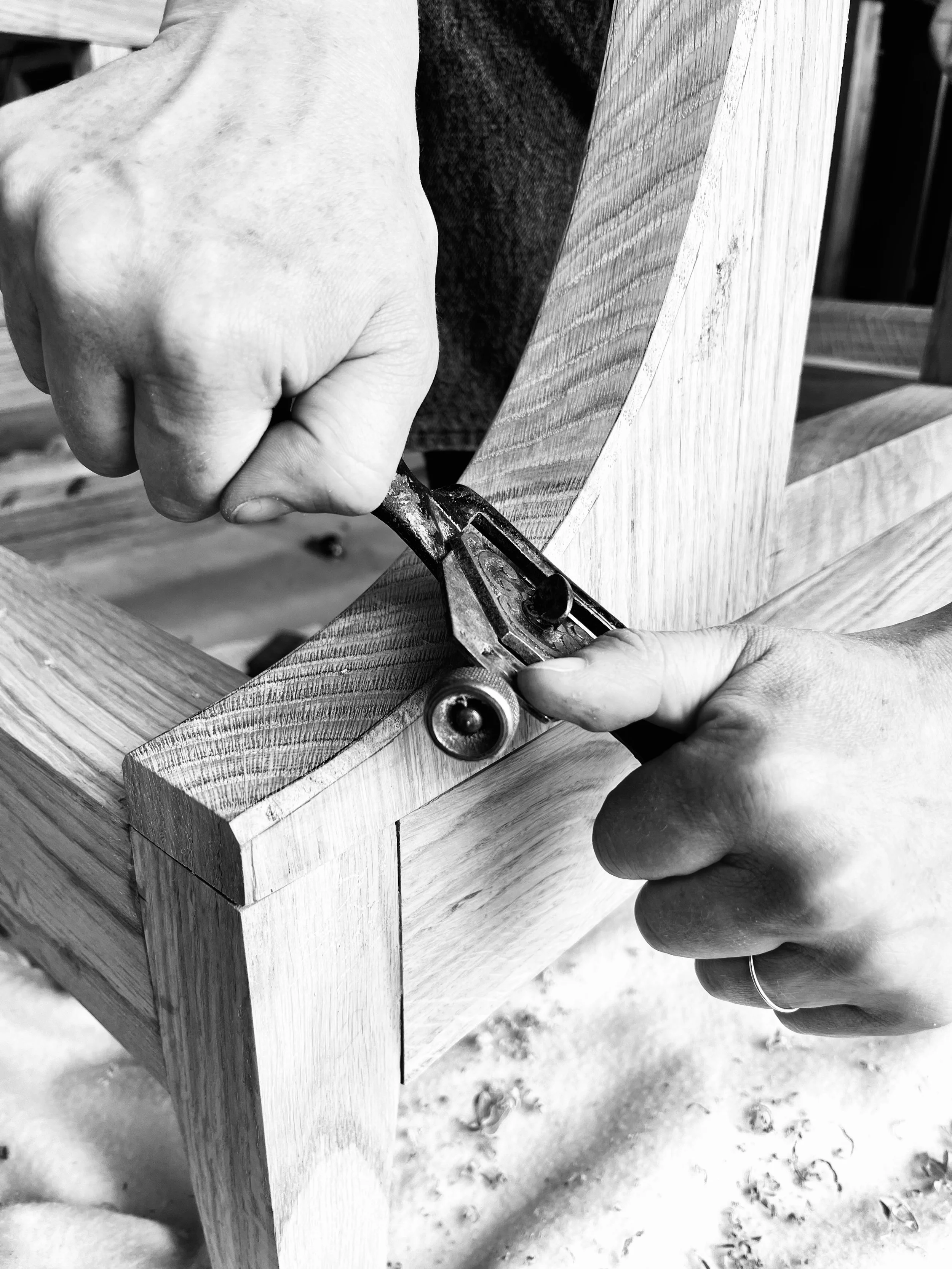 Emily uses a spokeshave to chamfer the edge of a bespoke scroll chair arm
