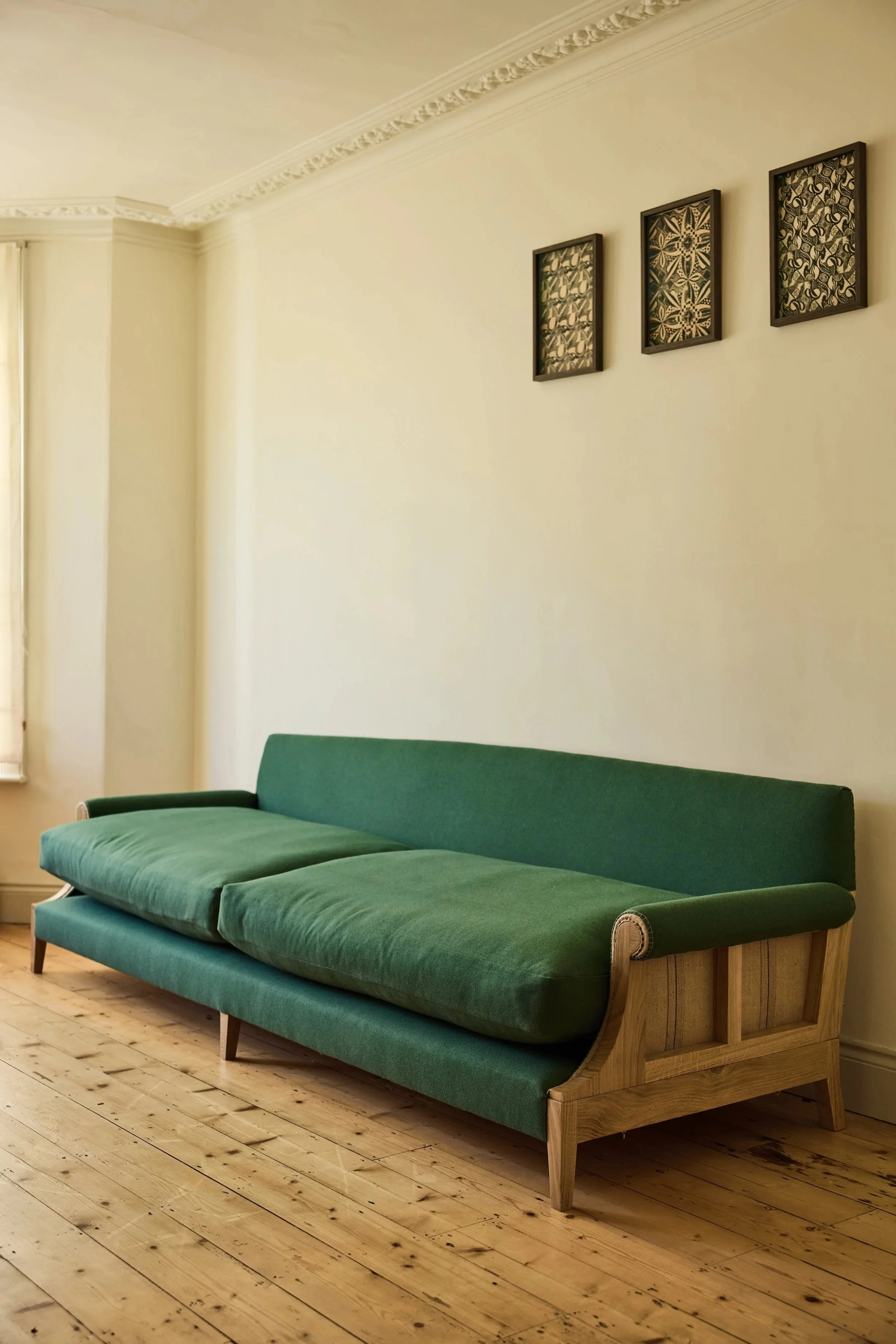 A bespoke size solid oak sofa. Designed and made in a workshop near the Cotswolds, its traditionally upholstered in a natural wool fabric in green and made to sit 6 people easily
