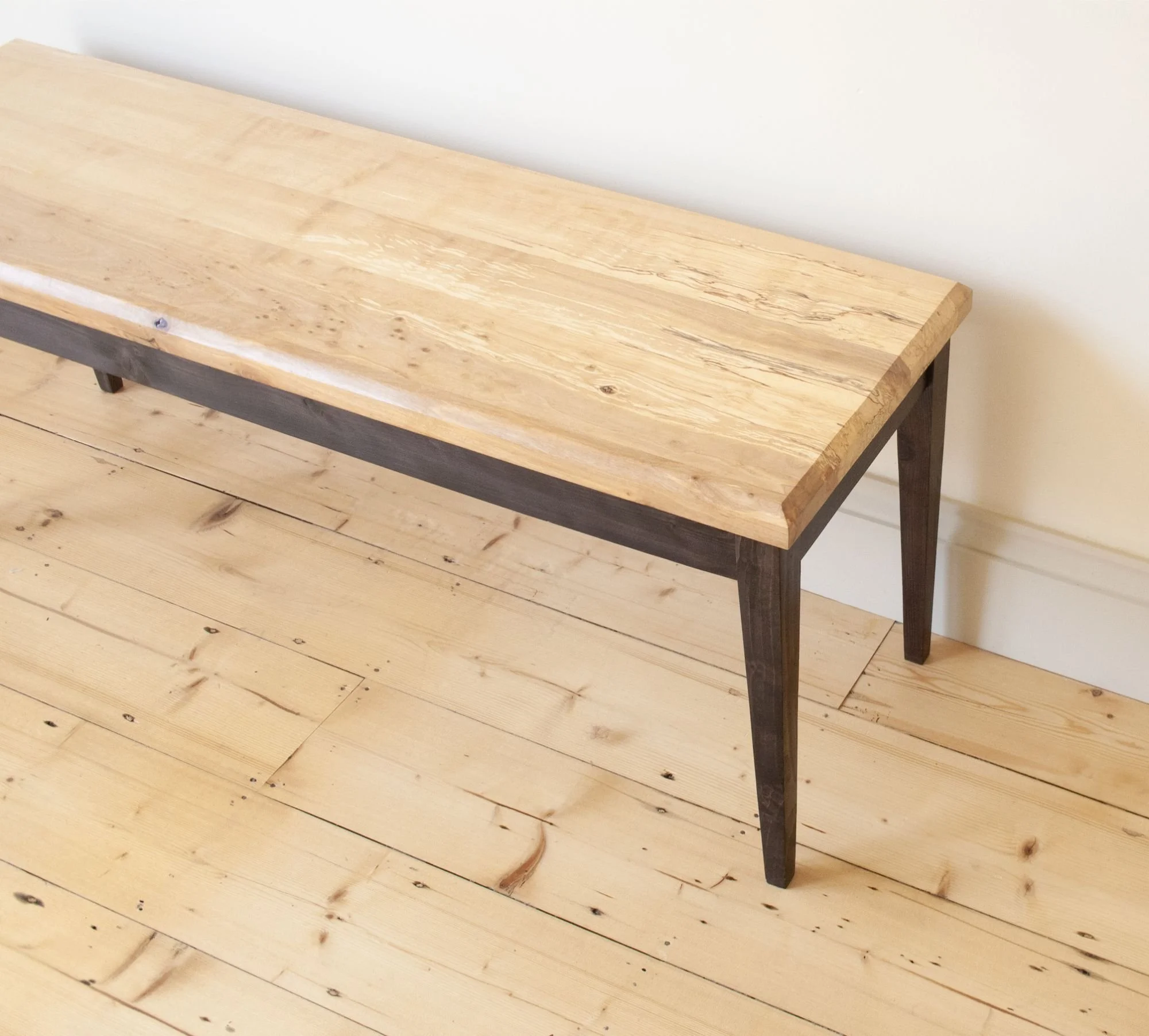 The Calder bench a simple black stained elegant leg frame with a spalted timber top