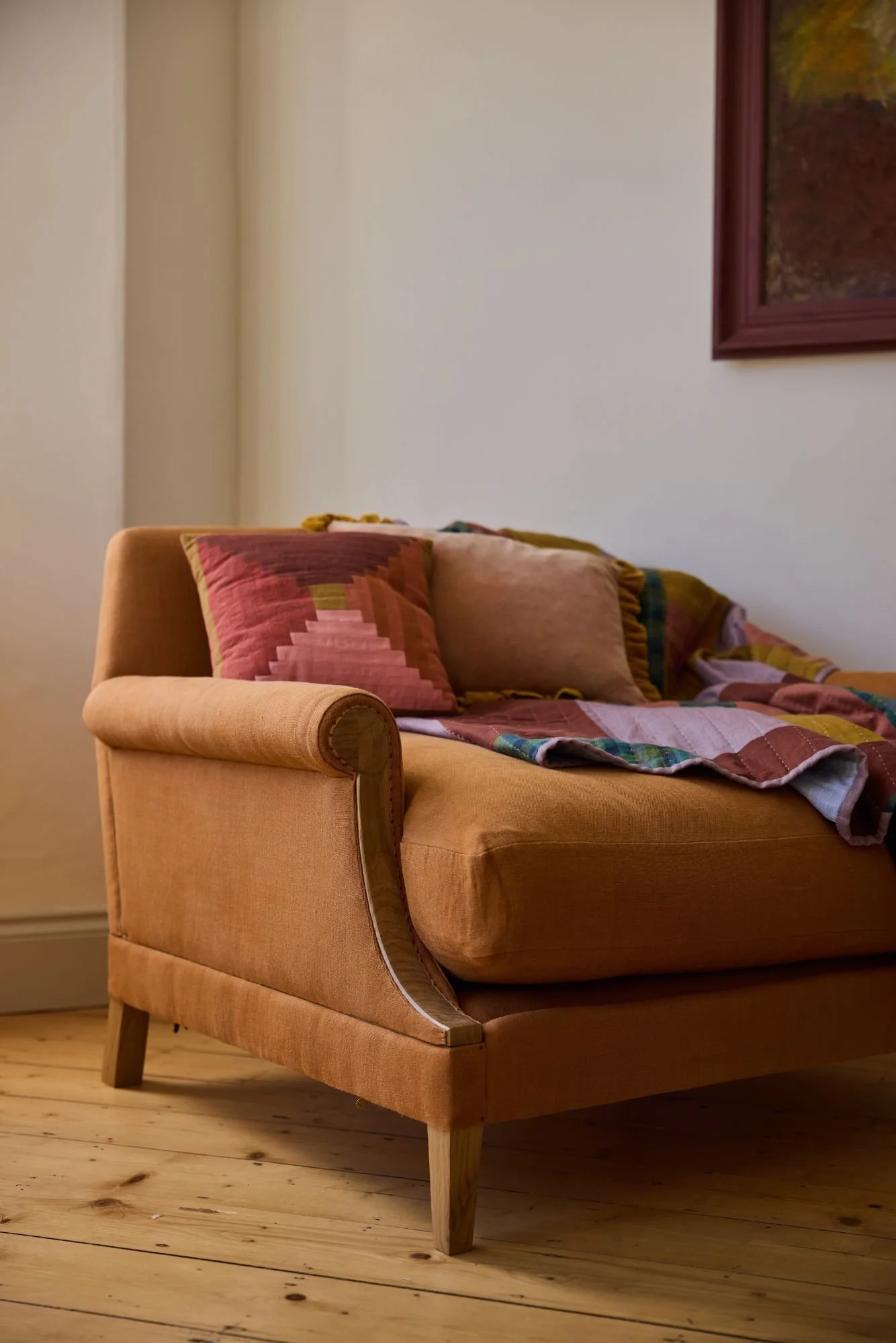Three quarter view of The Aldan bespome armchair styled with handmade textiles by Eelo & Ider quilt makers UK