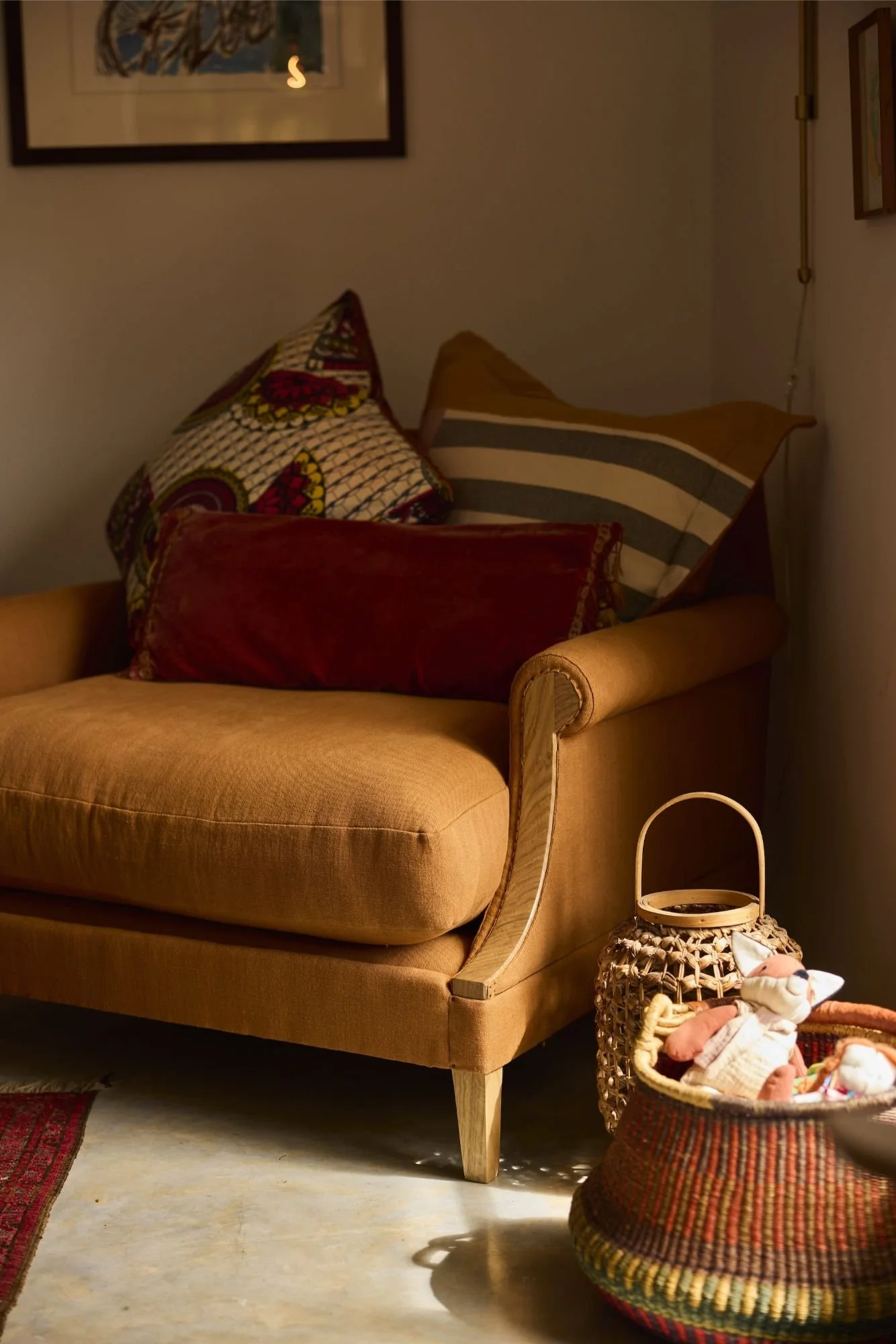 A cozy shot of The Aldan Loveseat in a lifestyle setting made with a solid oak frame and traditionally upholstered with a beautiful exposed arm using traditional upholstery tacks