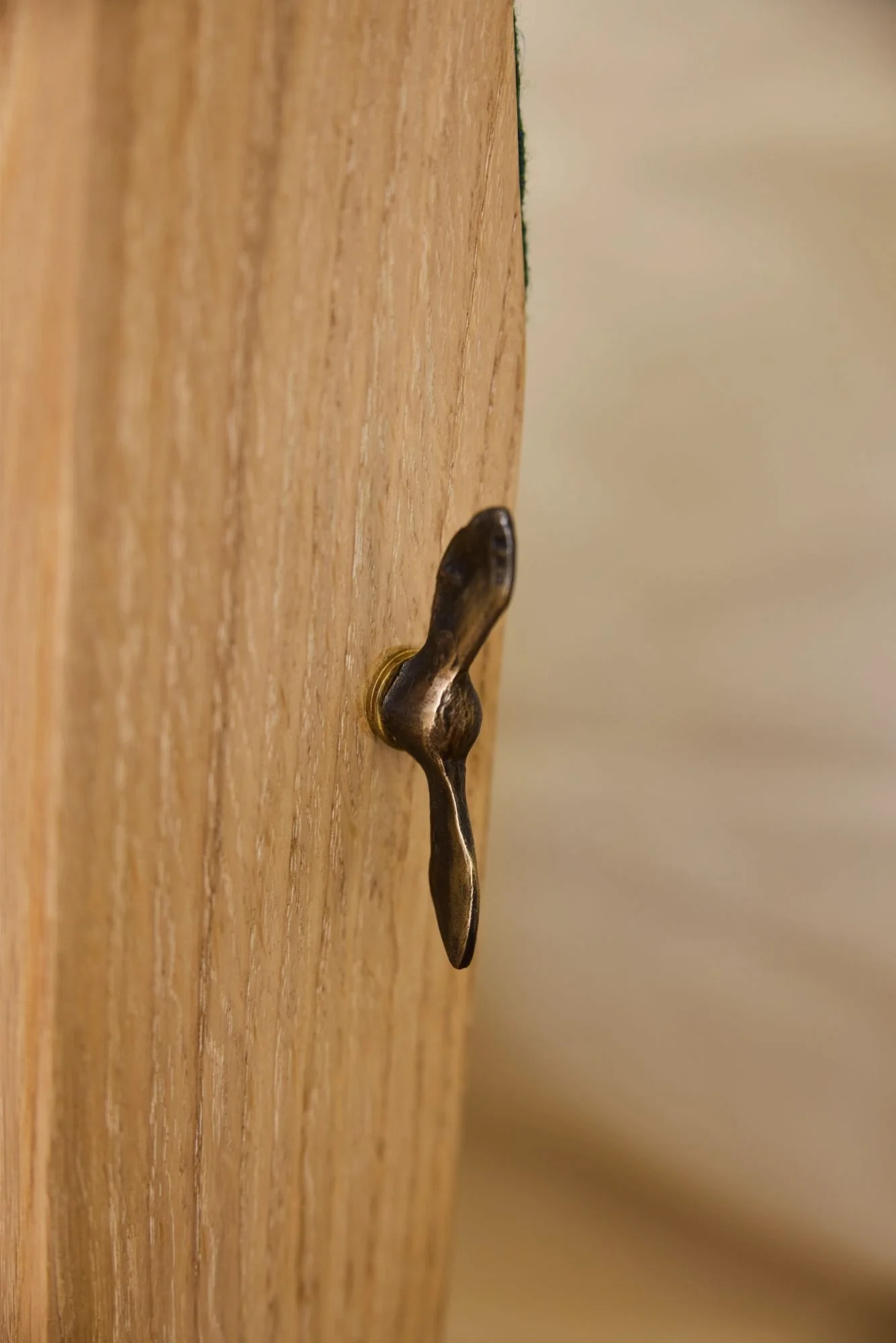 Close up of hand sculpted bronze hardware made bespoke for a custom sofa by furniture workshop Trew and Bold