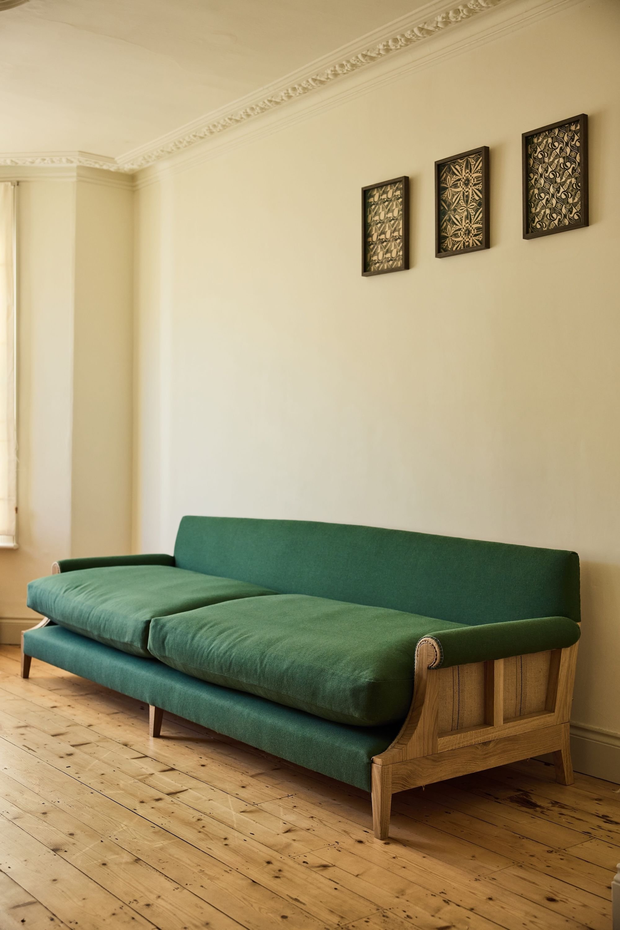 A bespoke size solid oak sofa. Designed and made in a workshop near the Cotswolds, its traditionally upholstered in a natural wool fabric in green and made to sit 6 people easily