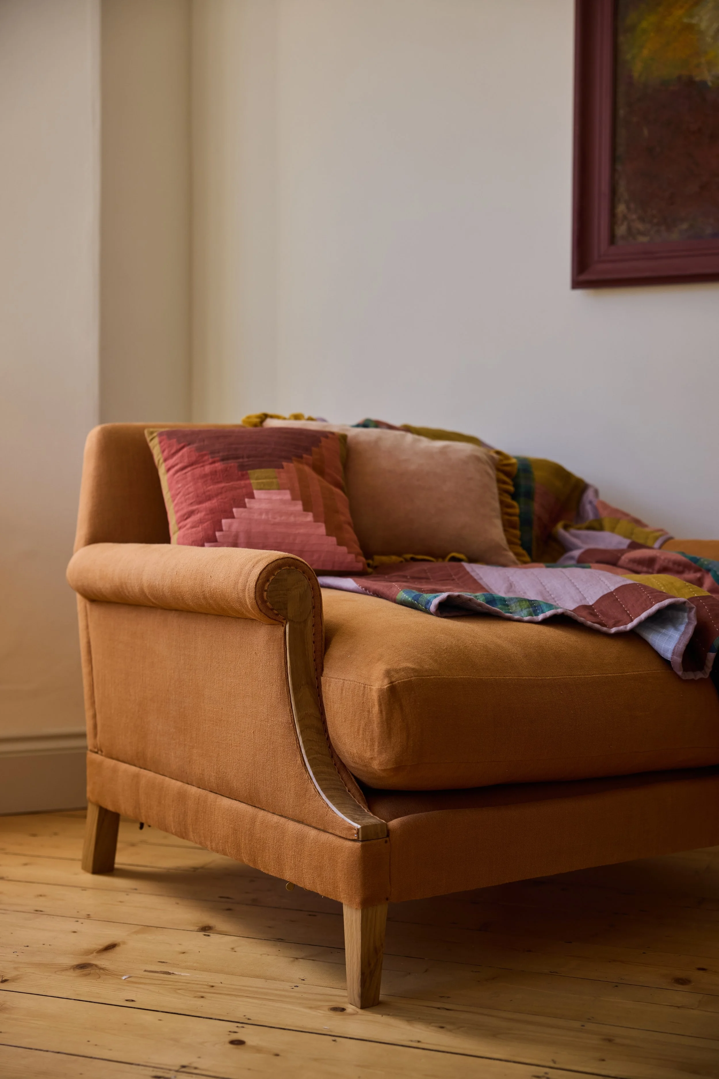 Three quarter view of The Aldan bespome armchair styled with handmade textiles by Eelo & Ider quilt makers UK
