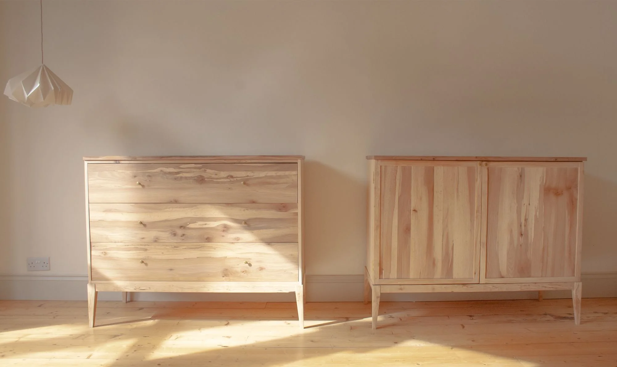The Thorne Chest of Drawers and the The Farrow Cabinet made by Trew & Bold in a mixture of carefully chosen solid wood, with ash carcass, silver birch legs and spalted elm drawer fronts