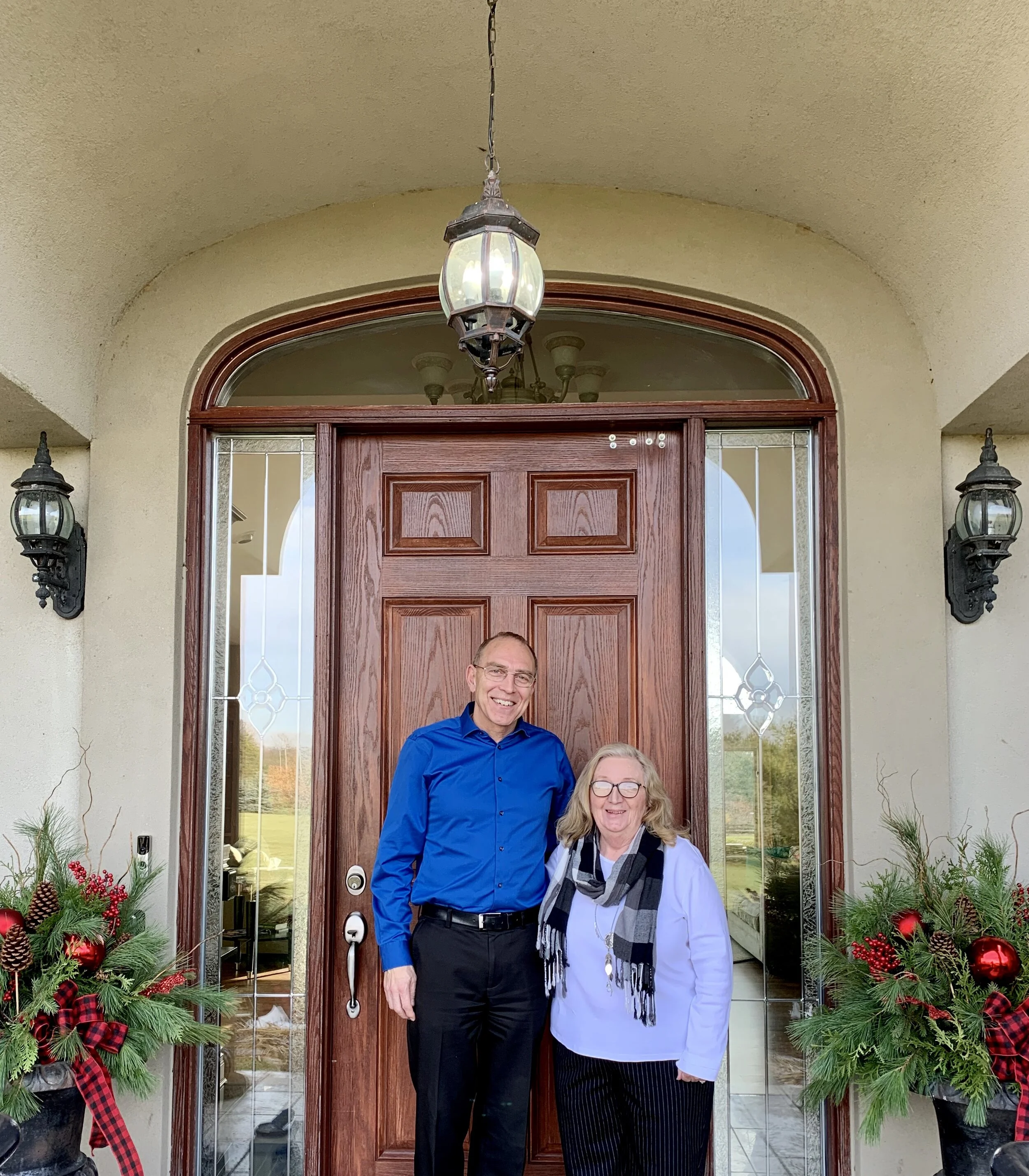 Incoming executive director Willy Van Klooster (left) with retiring executive director Shirley Dinsmore (right) at the front door of Huron Hospice Residence as they “pass the torch.”