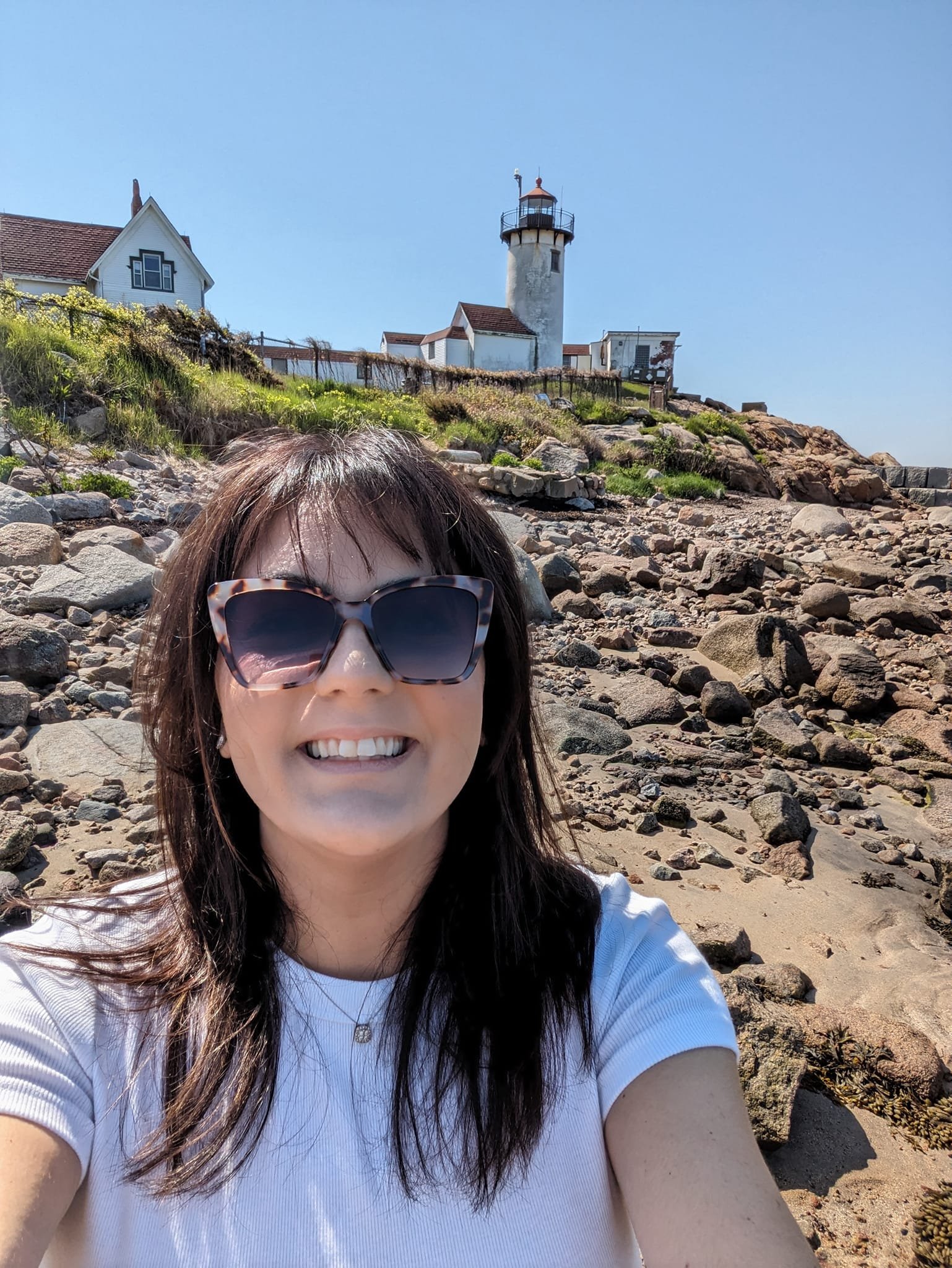 Women smiling with a lighthouse in the background