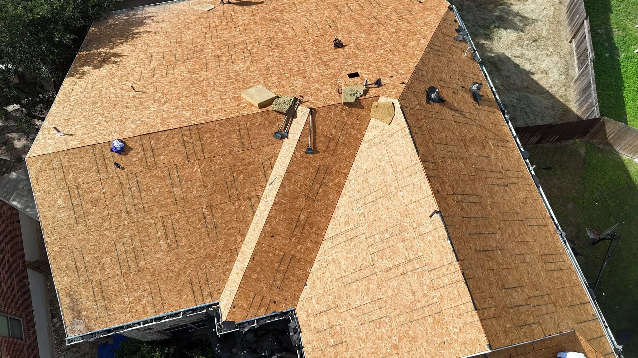 Aerial view of a house after tear down of the previous roof, all the way down to the decking.