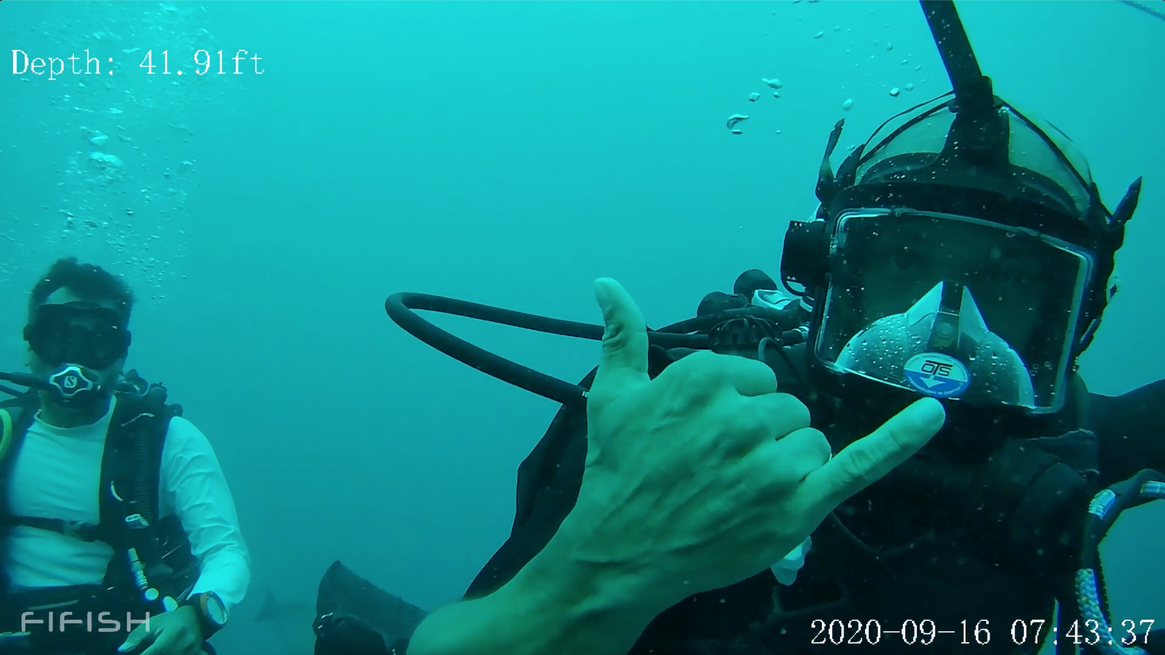 Two scuba divers underwater, one giving a thumbs-up and taking a selfie, with the other in the background. The water is blue-green and the depth is 41.91 feet, timestamped September 16, 2020, at 7:43:37.