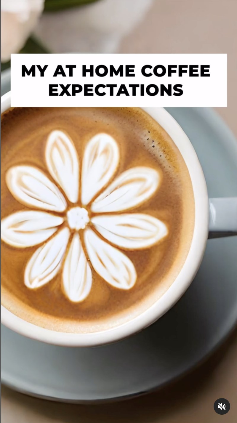 A cup of coffee with floral latte art on top, placed on a saucer
