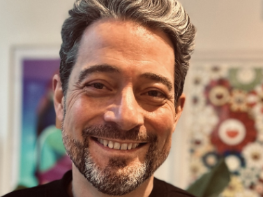 Close-up of a smiling man with gray hair and beard