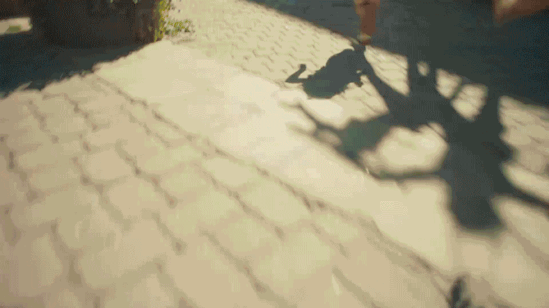 Shadow of a bicycle on a paved sidewalk during daytime with sunlight.