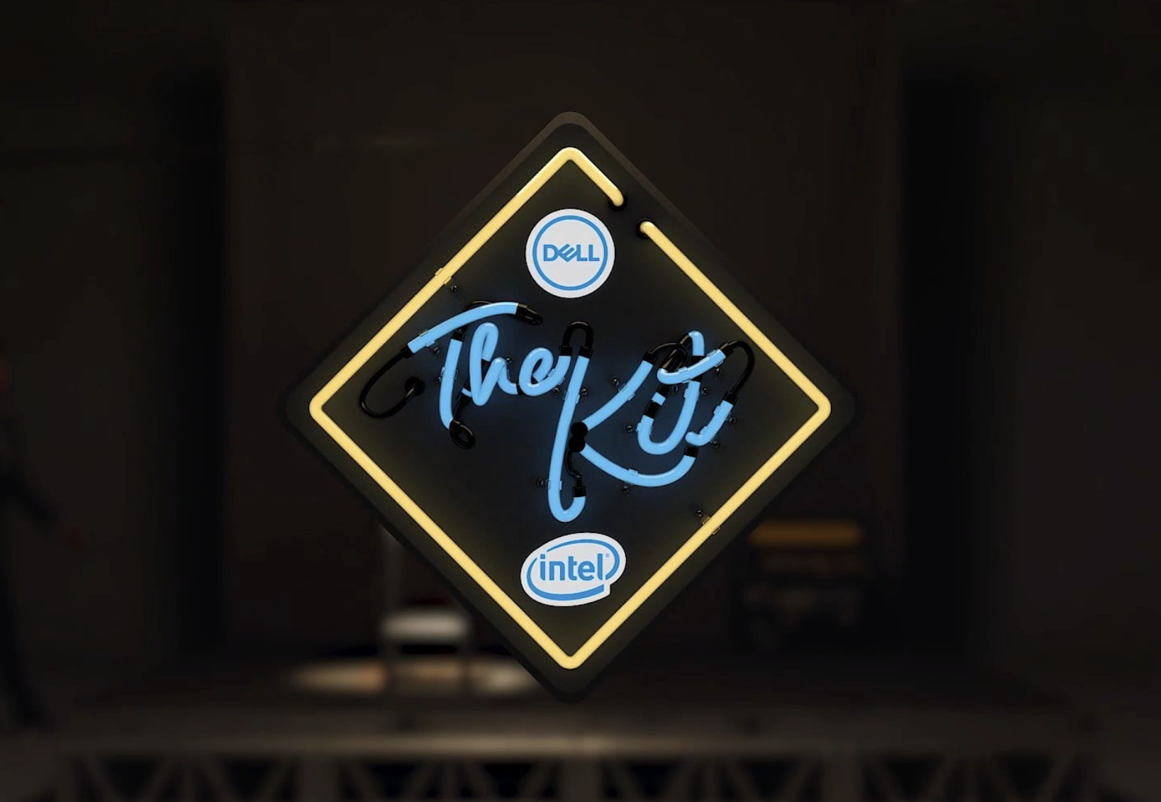 Neon sign with Dell and Intel logos, and the phrase 'The PC' in stylized blue cursive text inside a black diamond-shaped frame with yellow outline.