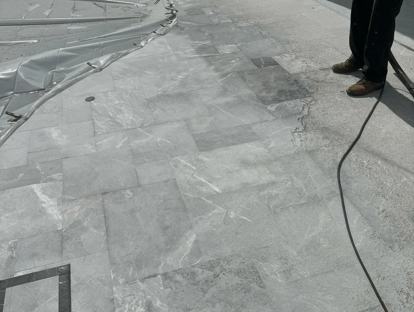 sandblasting to remove failed sealer and rust on a marble pool deck