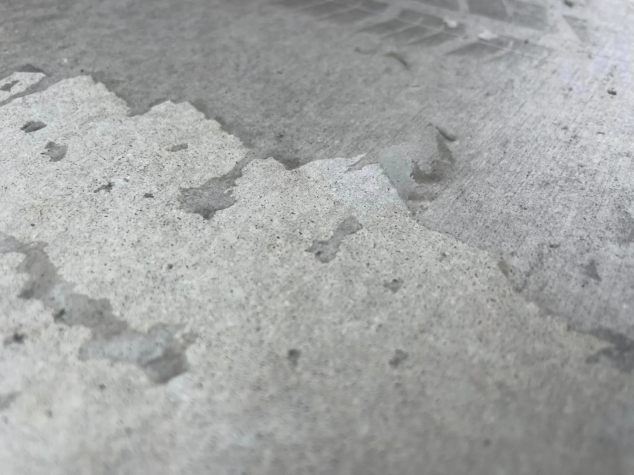 Close-up of a concrete surface with peeling paint or coating.