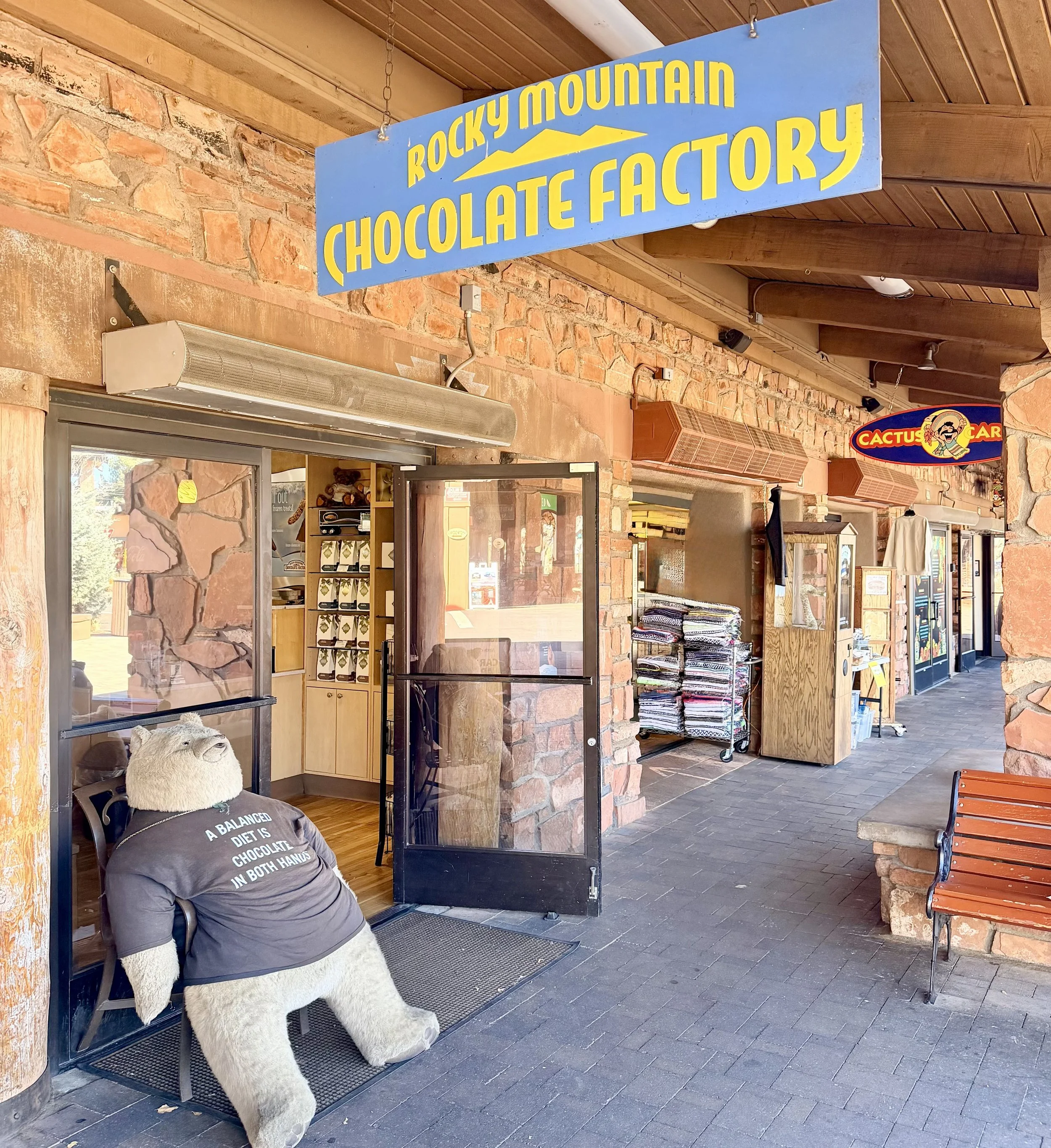 Sign for the Rocky Mountain Chocolate Factory hangs in front of the entrance to the store.
