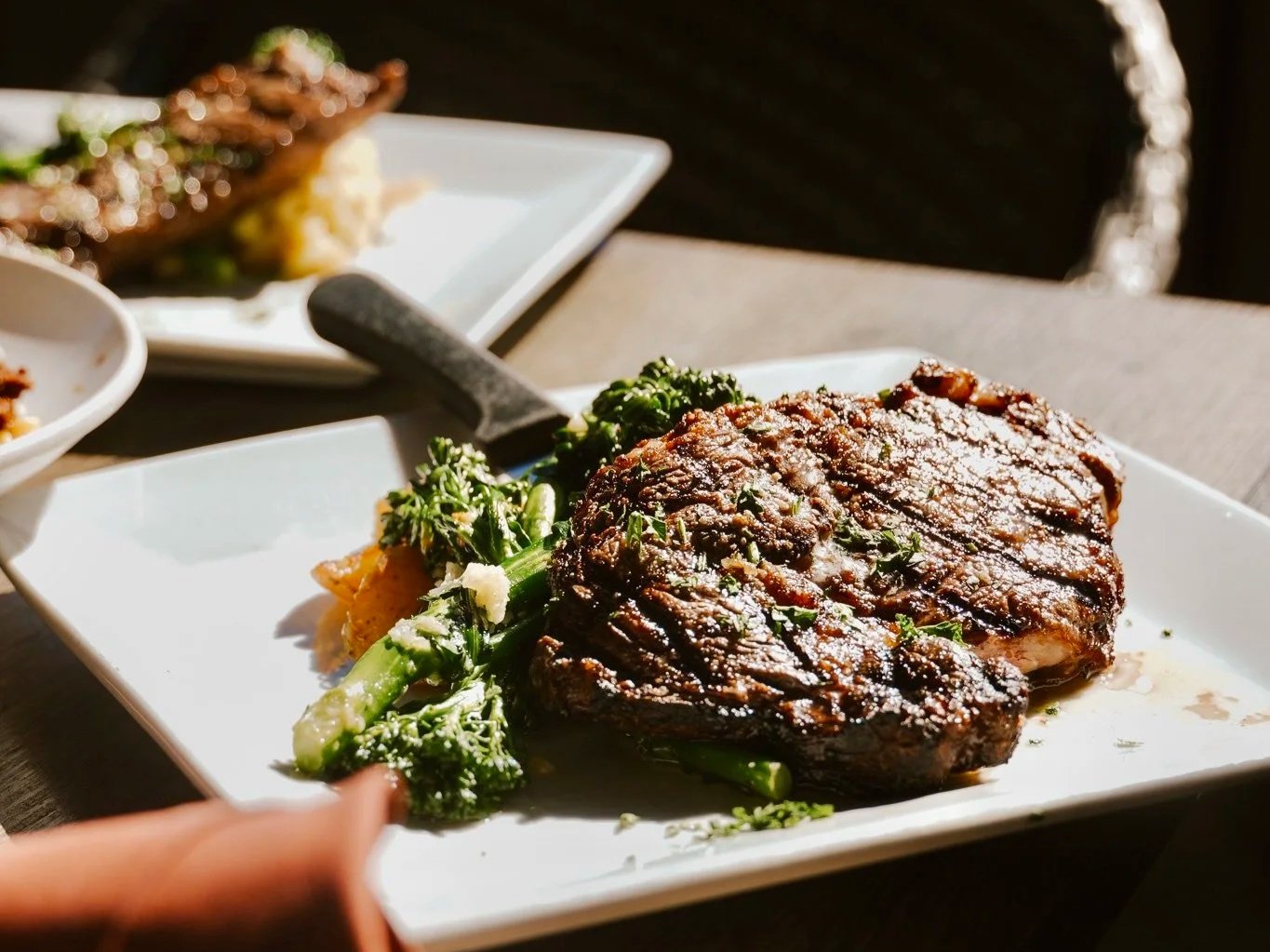Close up of a perfectly grilled New York Strip with broccoli side dish.