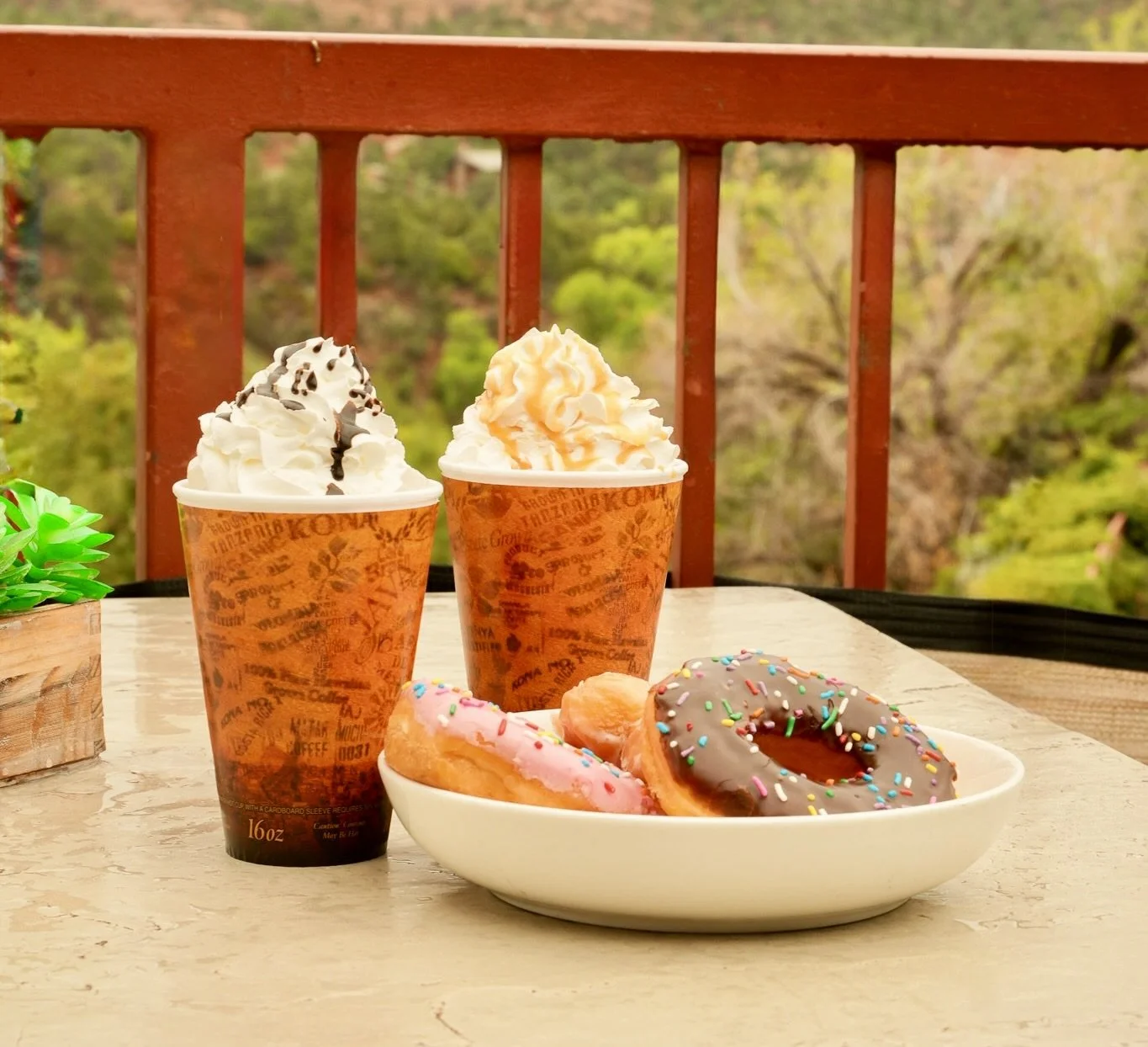 Specialty coffee drinks and donuts on a tray.