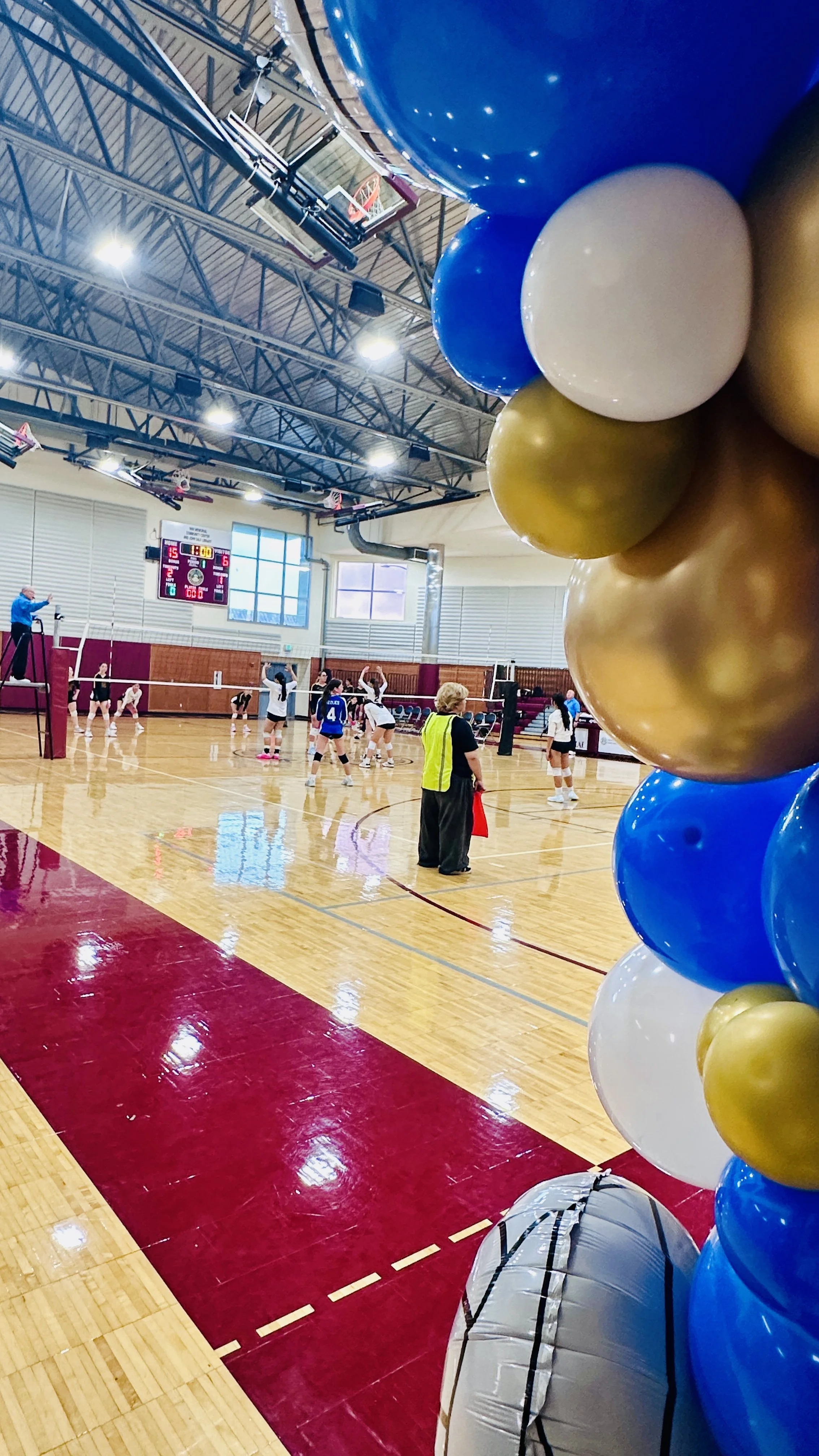 Volleyball foil balloon detail within a blue, white and gold tournament entrance arch in San Mateo.