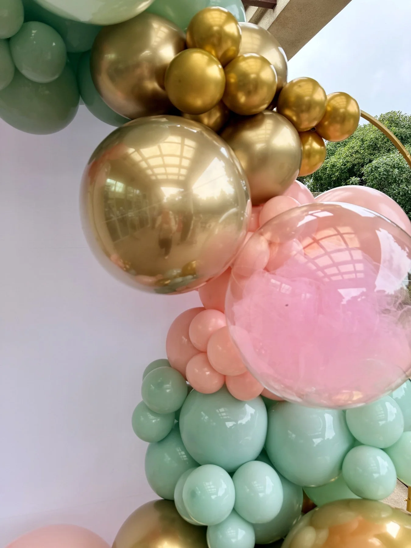 Reflective gold balloons and pastel mint clusters on a San Francisco First Holy Communion backdrop.