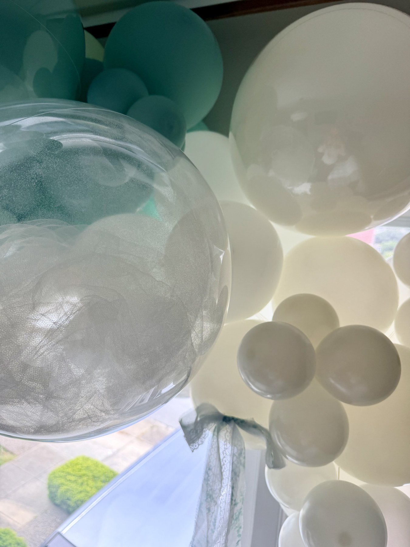 Clear bubble balloons and mint and ivory balloon garland for a San Francisco bridal celebration.