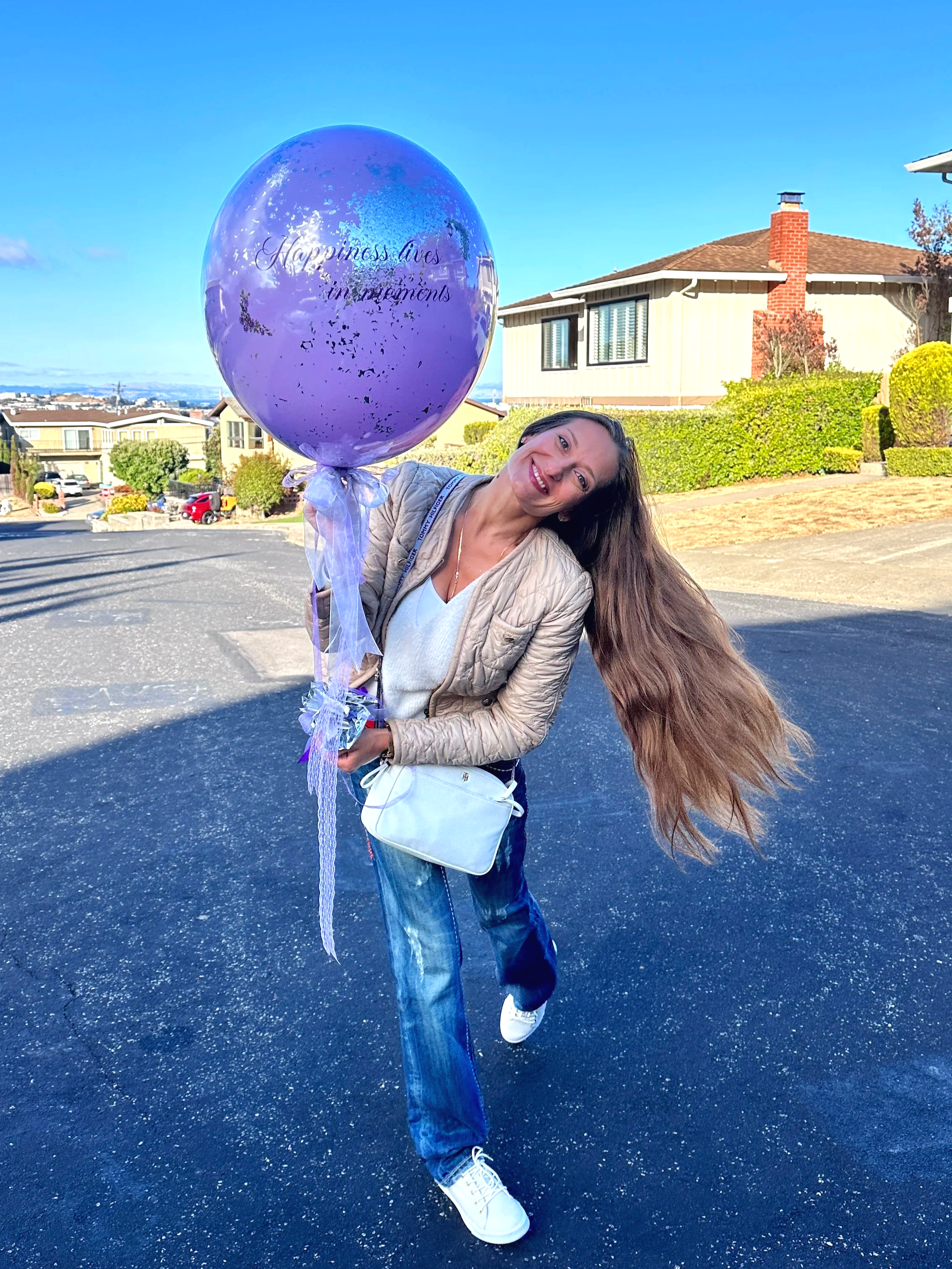 Woman holding a large purple helium balloon with confetti, perfect for birthdays and celebrations in Bay Area